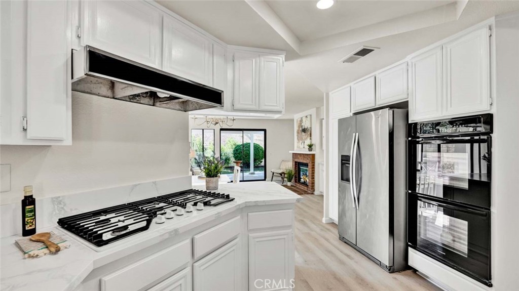 Experience the pinnacle of Chino Hills living in this stunningly remodeled residence, where over $100,000 in upgrades have transformed this property into a modern sanctuary. Nestled against the untouched beauty of Chino Hills State Park, this home boasts unobstructed panoramic views of rolling hills, wildlife, and endless skies—providing both privacy and serenity that can never be built over.Step inside to a light, bright, and airy floor plan adorned with soaring vaulted ceilings, expansive windows, and new vinyl plank flooring throughout the lower level and staircase. The heart of the home is the oversized living room with a dual-sided brick fireplace, nicely flowing into a formal dining room with designer chandelier, and a large separate family room w/breakfast nook.The showstopper is an updated chef’s kitchen featuring quartz counters, quartz backsplash, stainless steel farm sink, Whirlpool five-burner cooktop, dual Frigidaire ovens, and a large walk-in pantry with pullouts. This also has what every buyer is looking for: A spacious downstairs bedroom with adjacent full bath which makes for the perfect guest or in-law suite.Upstairs, retreat to your luxurious master suite (16’ x 14’)—a private haven with vaulted ceilings, double-wide closet organizers, a romantic tiled fireplace, and its own balcony with composite decking. From here, savor morning coffee as you watch birds and butterflies drift across the hillsides. The spa-inspired master bath impresses with a glass walk-in shower featuring subway tile and designer tile flooring, a soaking Jacuzzi tub,and dual sinks with modern fixtures.Two additional spacious bedrooms (12’ x 10’) share a stylish Jack & Jill bathroom with dual sinks and upgraded finishes.Additional highlights include: Brand-new HVAC system, indoor laundry room with overhead cabinetry (washer & dryer included),Two-car garage with built-in storage,Mature landscaping with adobe tile entry walkway,blooming flowers,and palm trees,Freshly painted interior and exterior,Gated front sitting area surrounded by flowers,Concrete tile roof for durability. The backyard is a private sanctuary, offering a covered patio, multiple sitting areas,and breathtaking sunset views over the park’s rolling hills.With no neighbors behind,you’ll enjoy the peace of nature in your own personal retreat.This rare property combines modern elegance, thoughtful upgrades, and one of the most coveted views in Chino Hills. Don’t miss the chance to make this dream home yours!