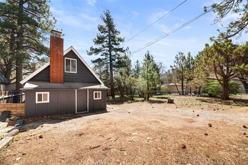 MOTIVATED SELLER Discover a blend of cozy living and outdoor potential in this delightful chalet. Featuring a spacious entryway/mudroom, this home welcomes you with warmth and character. The living space boasts a stunning brick fireplace, creating a cozy ambiance for chilly evenings. Upstairs, the wood-beamed bedroom offers a rustic touch and is adorned with beautiful wood floors, enhancing the home’s inviting atmosphere. Situated on an oversized 7,125 sq ft lot, this property presents endless opportunities with ample space for expansion, parking your RV or boat, or creating your own outdoor oasis. Storage is a breeze with two separate buildings on the property, one of which is equipped with electricity, providing an ideal workshop space for your hobbies or projects. Don't miss this unique opportunity to own a charming home with room to grow in a serene setting.