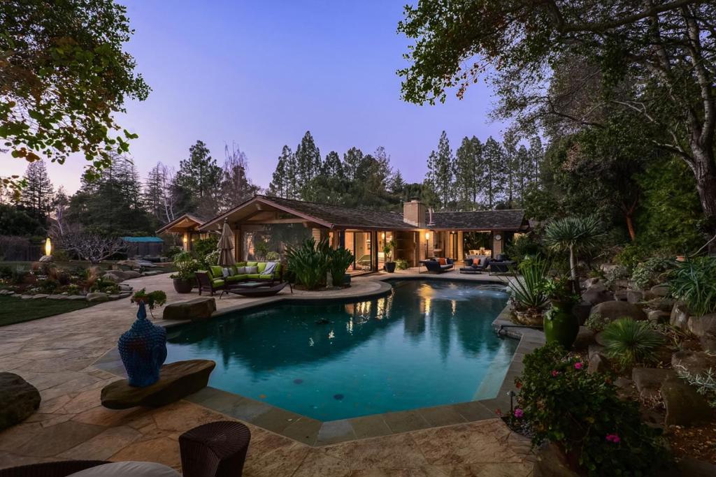 Sophisticated elegance for a luxurious California lifestyle with original architecture by Goodwin Steinberg and a full renovation by renowned builder RJ Dailey. Signature organic appeal with Zen tranquility, never more important than now and a one-level floor plan that takes full advantage of the grounds with meditation gardens, courtyards, atrium, and outdoor rooms designed for year-round living. Rare adobe construction plus Douglas fir, crushed limestone, floors in hickory or Saltillo tile, all new African Anigre cabinetry and hand-blown lighting. Well suited for today with plenty of space to work from home and distance learning. 2 customized offices, 4 bedrooms, each with en suite bath, large fitness center, wine cellar. Pool and private tub for outdoor bathing. Approx. 7,540 sf of indoor & covered outdoor living spaces. 1.7 acres with views of the western hills. Architecturally significant, unique, and not able to be replicated today - the ultimate luxury California lifestyle.
