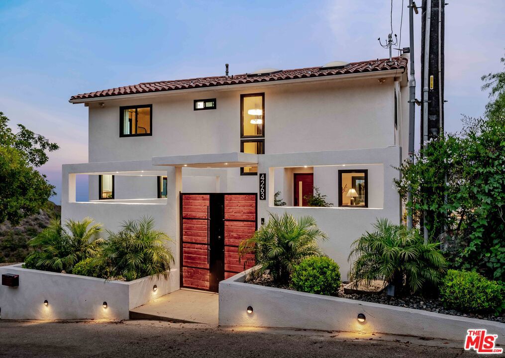 Tucked away on two beautifully landscaped lots totaling almost half an acre, this updated ocean-view retreat evokes the feel of a private Spanish villa. This 5-bedroom + detached office bungalow, 3-bathroom residence spans three light-filled stories, offering a harmonious blend of curated interiors, open flow, and tranquil spaces tailored for relaxed coastal living. Perfect for those seeking a slower pace and scenic surroundings, this remodeled property features refreshed landscaping and interiors filled with natural light, tile flooring, and custom finishes throughout. Off the main level, a beautiful ocean-view deck invites effortless indoor-outdoor living and entertaining as well as cosy corners for reading or work. Upstairs, the primary ensuite features a walk-in closet and a balcony escape well-suited for morning coffee with a view. Two additional bedrooms with a bathroom complete the upper level, along with another balcony that captures the surrounding beauty. Downstairs, two more rooms and a den add flexibility for use as guest rooms, offices or gyms. Additionally, a completely covered patio downstairs with beautiful views gives you another option to enjoy your beautiful surroundings. Lastly, past the manicured lawn, a quaint bungalow provides an incredible office space. Completely move-in-ready with sweeping views of the Pacific Ocean and Santa Monica Mountains, this is an ideal haven for anyone craving beauty, privacy, peace, and the finest of Malibu living.
