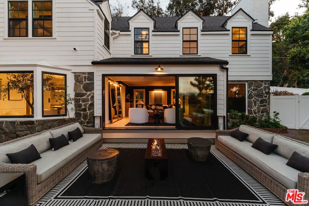 This property is offered on a long-term lease basis. Set on nearly an acre surrounded by vibrant, lush greenery sits this beautiful 1950's Traditional home. Gated and hedged, the property offers a serene and private escape from the city while being moments from both Beverly Hills and Studio City. Built by famed architect Gerard Colcord and recently reimagined over the course of 2 years by international designer, Julia Dempster, the two-story home showcases the perfect floor plan for both relaxation and entertaining. From the great room, a massive floor to ceiling glass door that frames picturesque canyon views slides open allowing seamless indoor/outdoor flow. Outfitted with custom cabinets, gold hardware and top of the line appliances, the kitchen is open to the informal dining area and family room with a fireplace and built-in shelving. Great for dinner parties or quaint evenings, the formal dining room looks out to the lush hills through large glass windows. Completing the first level, there is a guest room with an ensuite bathroom and a powder bathroom. Upstairs, you will find 3 bedrooms all with ensuite bathrooms and a moody office. The spacious primary suite features a bespoke fireplace, two bathrooms, two walk-in closets, and windows that welcome an abundance of natural light each day. The epitome of California living with multiple outdoor living spaces including two large patios, a pool, spa, and an outdoor kitchen. The property also hosts a 1 bedroom, 1 bathroom guest house adjacent to the pool that can also be used as a movie theatre, pool house or gym. For ultimate convenience, there is a 2 car garage and ample parking in the driveway.