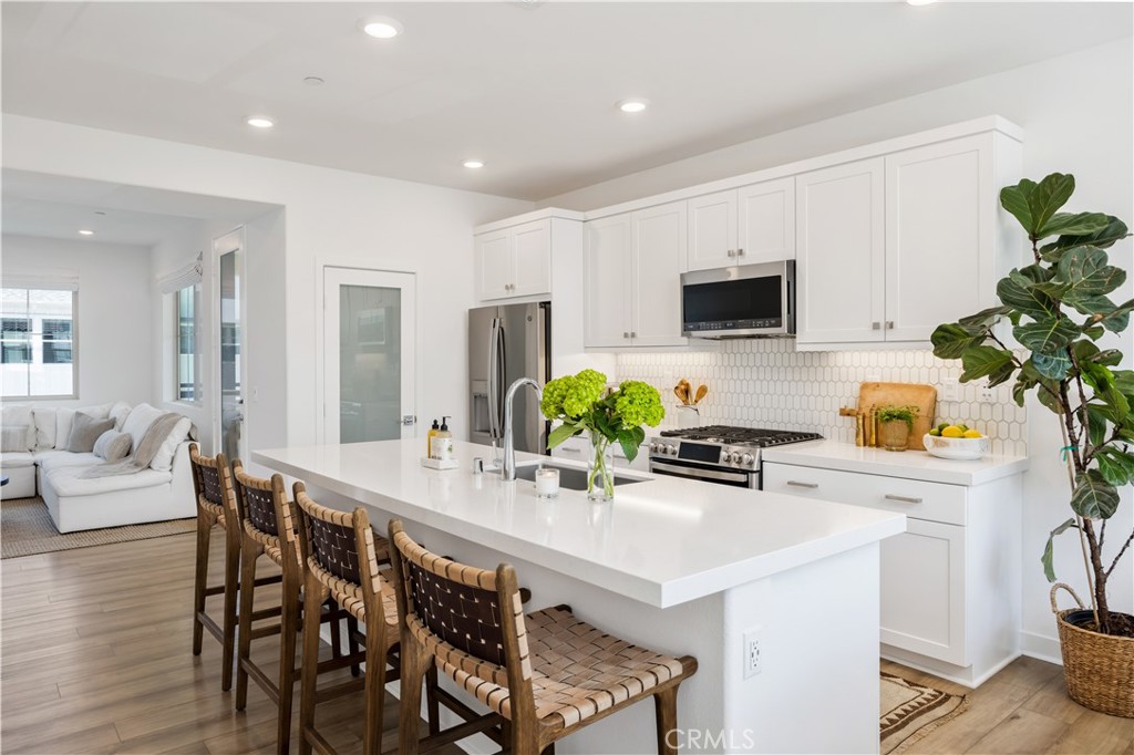 Welcome home to 111 Juniper Drive in the Oasis neighborhood of Rienda, part of the award-winning community of Rancho Mission Viejo! This designer-upgraded end-unit home offers 2 bedrooms, 2.5 bathrooms, plus a loft, and is situated in one of the best locations in the neighborhood. With only one shared wall, it lives like a single-family home and allows for an abundance of natural light. Featuring over $45,000 in upgrades, this home includes luxury vinyl plank flooring, upgraded floor tile, Roman shades, and stylish light fixtures. On the first level, you’ll find a bedroom with an en-suite bathroom, featuring a walk-in shower and glass sliding doors that lead to a private patio. Upstairs on the second level, enjoy an open floor plan with a dining area highlighted by a stunning chandelier and large windows showcasing beautiful views of Boulder Pond. The kitchen boasts an oversized island with quartz countertops, soft-close shaker cabinets, a ceramic tile backsplash, and stainless-steel GE Profile appliances. Relax in the cozy living room with direct access to the balcony — perfect for morning coffee or evening sunsets. Just off the kitchen is a conveniently located powder room, ideal for guests. A versatile loft on the third level also offers views of Boulder Pond and is perfect for a home office or can be converted into a third bedroom. Retreat to the primary suite, complete with chandelier lighting, a custom walk-in closet, and a generously sized bathroom with a dual-sink vanity, a walk-in shower with ceiling-high subway tiles, bench seating, and a TOTO heated bidet toilet seat. Also on this level is a separate laundry room with a stackable washer and dryer, as well as a hanging rack. Additional highlights include a two-car attached garage with epoxy flooring, overhead storage racks, added lighting, and a solar system. Ample guest parking is available, and the home is just a short walk to Boulder Pond, a playground, and Ranch Camp. Enjoy the exceptional amenities that Rancho Mission Viejo has to offer, including multiple resort-style pools, fitness centers, parks, sports courts, an arcade, a dog park, hiking trails, and so much more!