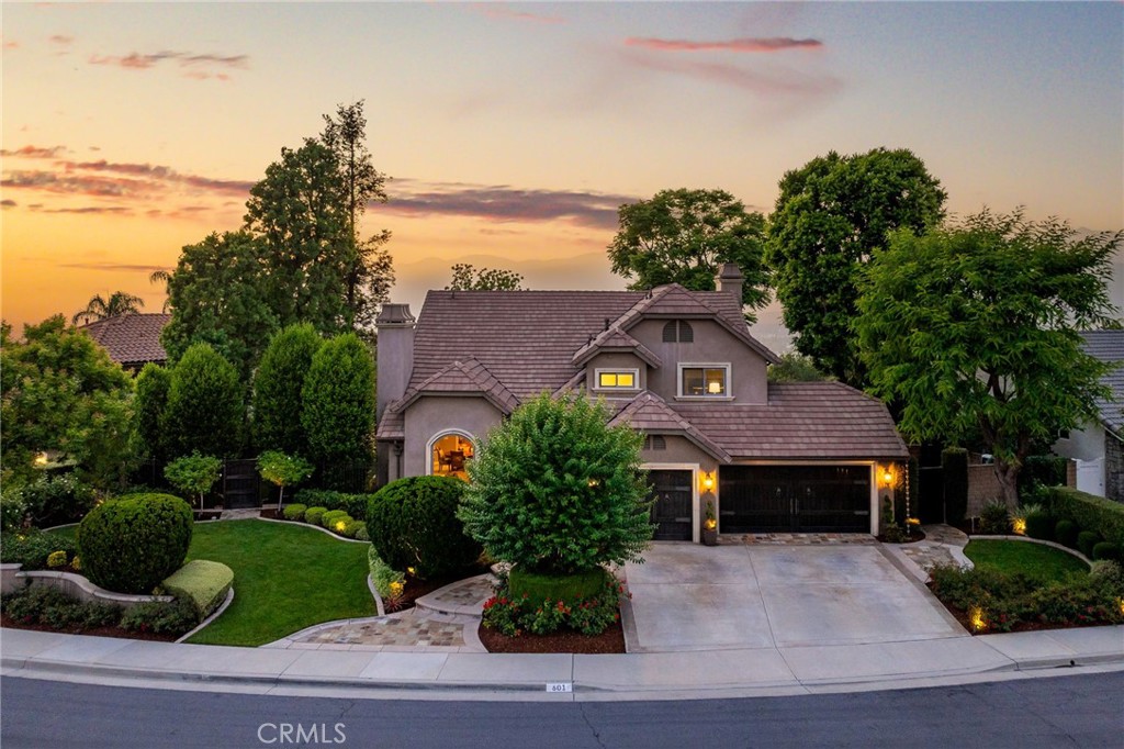 Panoramic city lights and mountain views surround this reimagined home, transformed with over $1.2M in custom upgrades into the crown jewel of Regency Hill, a private gated community in Via Verde. Perched on a prime view lot, this sanctuary showcases a Santa Barbara smooth stucco exterior, handcrafted mahogany garage doors and gates, Provence chimney crowns, and a dazzling landscape design—meticulously lit to rival Disneyland—complete with an elegant fountain and extensive natural-stone hardscape. A covered front porch opens to double mahogany doors and hand-scraped engineered hardwood floors. Inside, every detail reflects uncompromising quality: a Level 5 drywall finish, England-trained master carpentry, solid 1-3/4 inch interior doors with Churchill hardware, advanced security, professional-grade Wi-Fi, Sonos sound, and Lutron automated lighting. The open, light-filled floor plan begins with a direct sightline from the entry to the backyard and mountains beyond. A sweeping staircase and soaring ceilings frame the formal living room and adjacent dining room, accented by exposed beams, an arched picture window, and a sophisticated fireplace. The kitchen features custom inset cabinetry, quartzite countertops, stainless steel appliances, concealed ambient lighting, and a farmhouse sink positioned to capture breathtaking vistas. A peninsula with bar seating and a breakfast nook with French doors transition seamlessly to the open family room, where a custom fireplace, flush-mounted surround sound, and three expansive picture windows frame the million-dollar view. The main floor also offers a guest bedroom with French doors to the backyard, a full bath, and a laundry room with access to the fully finished three-car garage with Factory 1 epoxy floors. Upstairs, the primary suite boasts vaulted ceilings and unobstructed views. Its spa-like bathroom features dual sinks, a marble-surround soaking tub with views, a frameless glass shower, and a walk-in closet. A hallway with custom cabinetry leads to two additional bedrooms—one currently designed as a home office—and a stylish bathroom. The backyard is an entertainer’s dream, with a pebble-finished pool and oversized spa with cascading spillway, Pentair UltraUV sanitizer, iAqualink controls, custom hardscape, fire pit, elevated planters, and mature trees—all set against a sweeping panoramic backdrop.