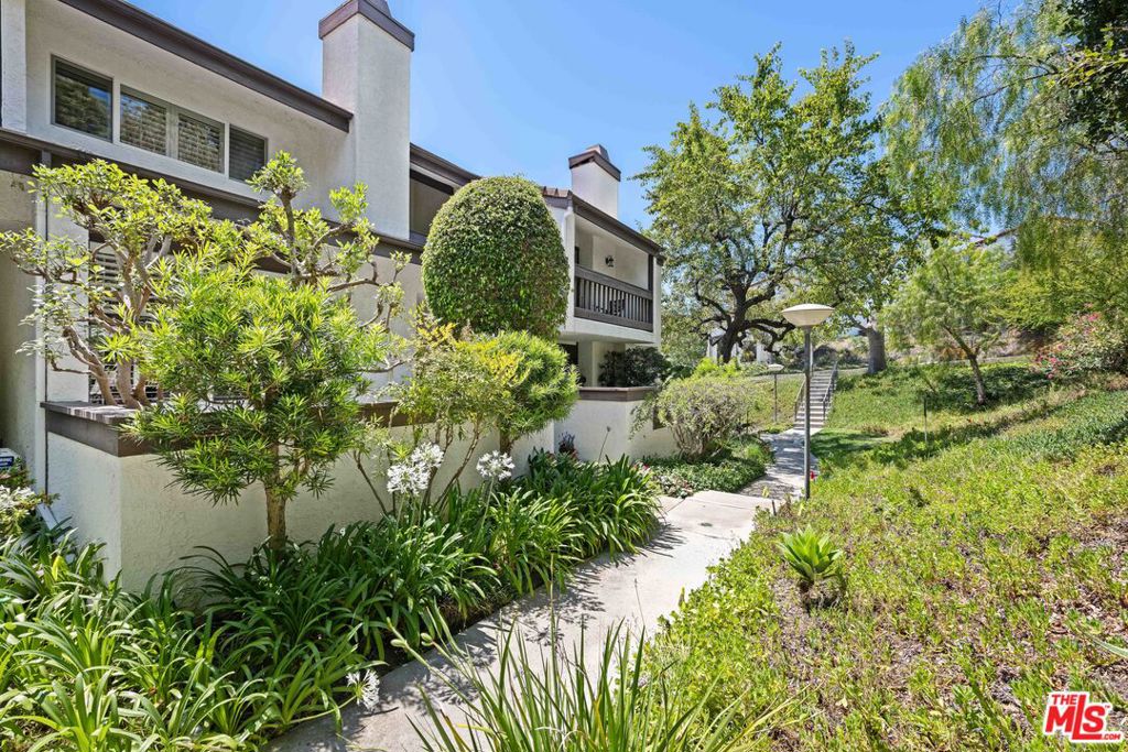 Tucked away in the tranquil, resort-like setting of the Palisades Highlands, this beautifully maintained townhome offers 2 bedrooms, 2.5 bathrooms, and a spacious bonus room perfect for an office, den, or optional third bedroom. Surrounded by lush, manicured landscaping, this serene retreat features an open-concept layout with vaulted ceilings, rich hardwood floors, and seamless indoor-outdoor flow. A peaceful, enclosed patio with a BBQ gas line invites al fresco dining, while oversized sliding doors and plantation shutters bring natural light and charm into the living space. The living room is anchored by a cozy fireplace and flows effortlessly into an elevated dining areaideal for entertaining. The fully equipped kitchen boasts stainless steel appliances, ample cabinetry, and easy access to the versatile bonus room. A stylish powder bath with a custom vanity completes the main level. Upstairs, the spacious primary suite offers soaring ceilings, a private balcony with scenic views, a walk-in closet with custom-built-ins, and a luxurious en-suite bathroom. The second bedroom also includes its own en-suite bath and enjoys picturesque mountain views. A convenient laundry area is located just outside the bedrooms. Additional features include a private 2-car garage with abundant storage and direct unit access. Community Amenities include a heated pool & spa, lighted tennis courts, fitness room & sauna, and 24-hour Highlands patrol with ACS. Ideally located just up the canyon from Sunset Blvd, you're moments from scenic hiking trails, Palisades Village, beaches, and the best of Malibu and Santa Monica.1622 Palisades Drive offers a rare combination of privacy, beauty, and convenience - an exceptional value in the Highlands.