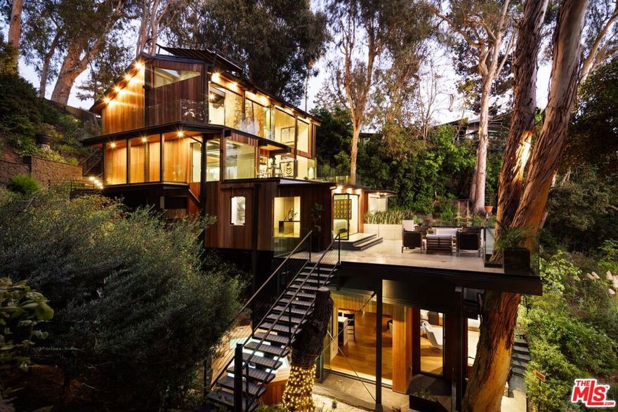 Framed by the flourishing landscape of the prestigious Riviera, 1509 Amalfi Dr is a study in serenity, inviting stillness, connection, and renewal across more than half an acre of tranquil grounds. Set behind private gates, a discreet entry gives way to an open, ethereal interior. Sunlight filters through expansive walls of glass, revealing cinematic ocean and canyon views, blurring the boundary between the indoors and out. The bespoke Italian kitchen by renowned D.I. Group is both sculpture and sanctuary, featuring hand-finished Chukum countertops, state-of-the-art appliances, and a hyper-filtered reverse osmosis alkaline water system offering hot/cold, or carbonated mineral water at the touch of a finger, that blends innovation with intention. Each bedroom suite evokes the sensibility of a private wellness retreat, defined by clean lines, natural textures, and an effortless flow with unparalleled space, privacy, and comfort. Thoughtfully curated amenities, including approved plans for an elevator, invite restoration and ease: a Rejuvenation Spa with contrast therapy, cold plunge, and sauna; a glass-paneled plunge pool that floats above the surrounding landscape; a meditation garden known as Inspiration Point; and a private vineyard with a wine terrace beside gentle waterfalls. A secluded guest casita offers a quiet retreat, while radiant-heated en-suites and intimate spaces bring warmth and balance to daily living. Here, every detail reflects the art of intentional living. Embraced by nature yet moments from the best of the Westside, 1509 Amalfi Drive is more than a residence; it is a sanctuary for the senses. A place to retreat, restore, and simply be. One you won't want to miss.