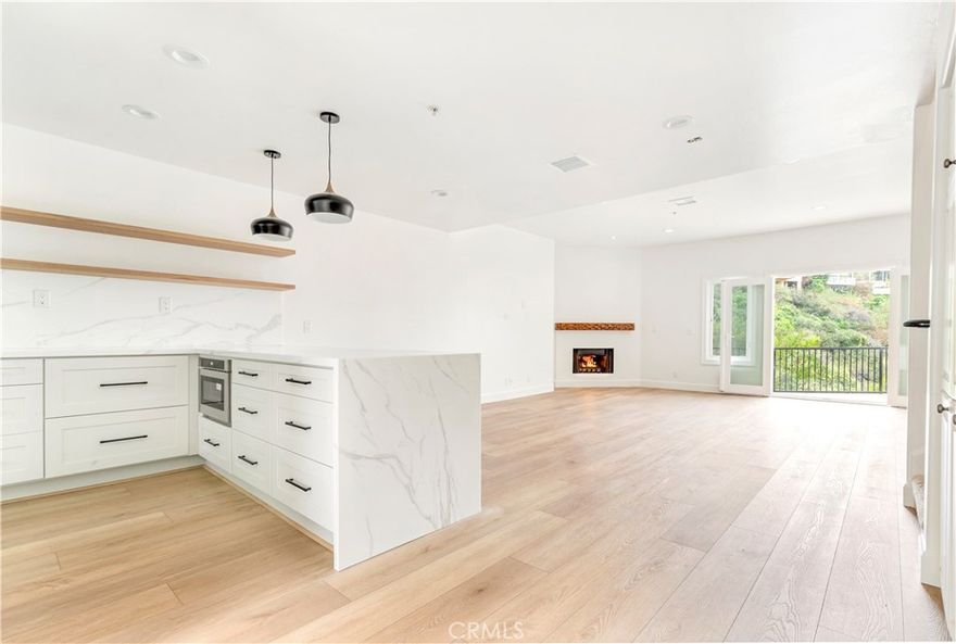 Completely renovated 3 bedroom, 2 ½ bath condominium in the gated Villa Del Este with a generous, flowing floor plan, highlighted by organic light, new flooring, updated bathrooms and canyon views. The expansive kitchen has been completely transformed, offering ample cabinetry, sprawling quartz counters, breakfast bar, and brand-new appliances including a 6 burner range oven, fridge, and floating shelves. It seamlessly connects to the dining room and living room complete with large fireplace and a viewing deck overlooking Buck Gully. Upstairs, the primary suite provides copious closet space and spacious bathrooms with tub and shower. The property includes two parking spaces in the secure subterranean garage, as well as an approximately 8'x8' storage area within the garage. Live the Corona del Mar Lifestyle near world-class beaches, state-of-the-art dining and renown shopping.