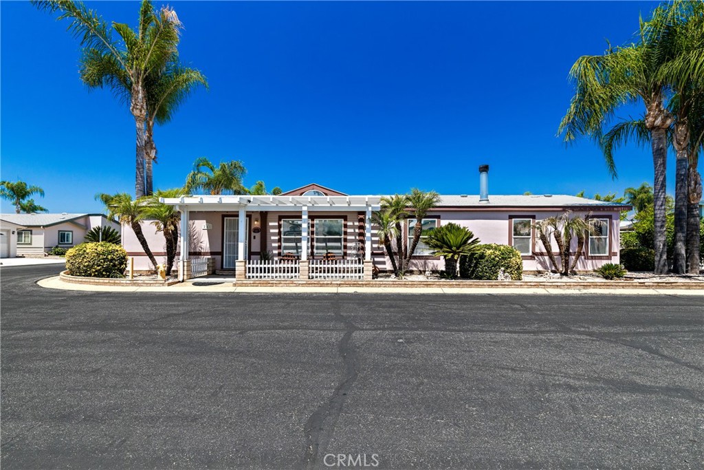 Welcome to the gated 55+ Foothills of Hemet community, where you’ll find this spacious 3 bedroom 2 bathroom 1,848sqft home on a desirable CORNER LOT, filled with natural light, soaring ceilings, and an OPEN-CONCEPT layout perfect for relaxed living. Step inside to a bright and airy living and dining area that has a modern, elegant feel. The open kitchen features a center island and flows seamlessly into a cozy family room with a fireplace-ideal for entertaining or quiet evenings. The primary suite offers a walk-in closet and en-suite bath with dual sinks, soaking tub, and walk-in shower. Two additional bedrooms with new carpet, a second full bath, and a dedicated laundry room are located on the opposite side for added privacy. Outside, enjoy the added storage of a private shed and the spacious feel of a corner lot. The community features a beautiful clubhouse, two pools, sport courts, and a wide range of social activities. With pet restrictions, low taxes, and affordable lot rent, this well-managed, clean, and friendly park is just minutes from shopping and local amenities.