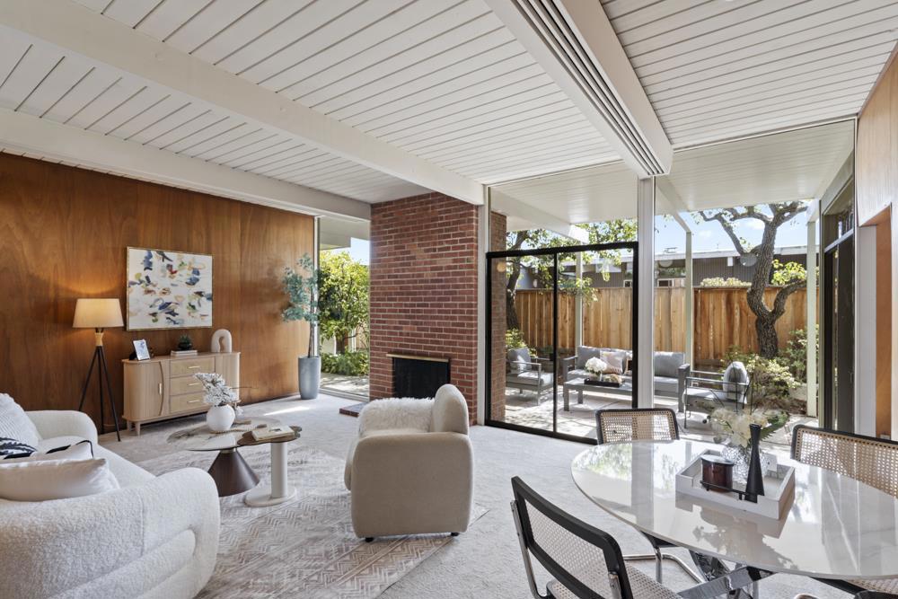 Mid-century charm meets everyday convenience in this 4-bedroom, 2-bath home in 19th Avenue Park neighborhood. A broad shade tree and post-and-beam facade introduce the home, with a side walkway leading to a quiet entry. A stained-glass sidelight, terracotta tile, and globe lighting overhead mark your arrival inside. The light-filled living and dining area features original wood paneling, fresh carpet, and a floor-to-ceiling glass wall framing rear patio views anchored by a red brick fireplace. The kitchen retains its original footprint with warm cabinetry, vintage lighting, and access to the two car garage with ample built-in storage. A flexible secondary living space could be used as a den, office, or media room. Multiple outdoor areas wrap around the home include distinct patio areas and additional outdoor space anchored by established landscaping. The private wing hosts a primary suite with patio access, dual closets, and ensuite bath, plus three addl bedrooms are served by a hall bath. Commuting is easy, just blocks from Hayward Park Caltrain and easy access to Highways 92, 101, and 280. Downtown San Mateo is less than a mile away, making this both a connected retreat and a rare opportunity to own a piece of iconic mid-century architecture in a central Peninsula location.