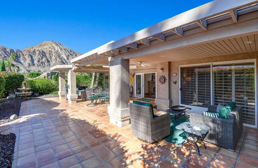 This beautifully private residence offers classic Spanish Colonial charm and effortless indoor-outdoor living, highlighted by a sun-filled, south-facing backyard with a fully covered, oversized patio and breathtaking mountain views abound. Backing directly to a lush greenbelt, the home enjoys rare privacy and tranquil desert surroundings, while one of the community's sparkling pools sits just steps away. Inside, warm, inviting tones are accented by authentic Saltillo tile flooring found both indoors and throughout the outdoor living spaces. High ceilings are enhanced with elegant crown molding, while multiple solar tubes create an airy, light-filled atmosphere. Plantation shutters add timeless style throughout, while thoughtfully updated kitchen and bathrooms blend classic charm with modern convenience. The garage features clean, upgraded epoxy flooring, adding both function and a polished finish. Located within the sought-after Laguna De La Paz lake community, residents enjoy access to 15 pools, 16 spas, 5 tennis courts, 2 pickleball courts, a well-equipped fitness center, and an active clubhouse. A favorite centerpiece of the community is the stunning 4+ acre lake, complete with a scenic walking path, lakeside gazebos, and resident-only pontoon and pedal boats--perfect for sunrise strolls, relaxing afternoons, and peaceful boat rides. Experience resort-style living, natural beauty, and a true sense of community--all in one exceptional home.