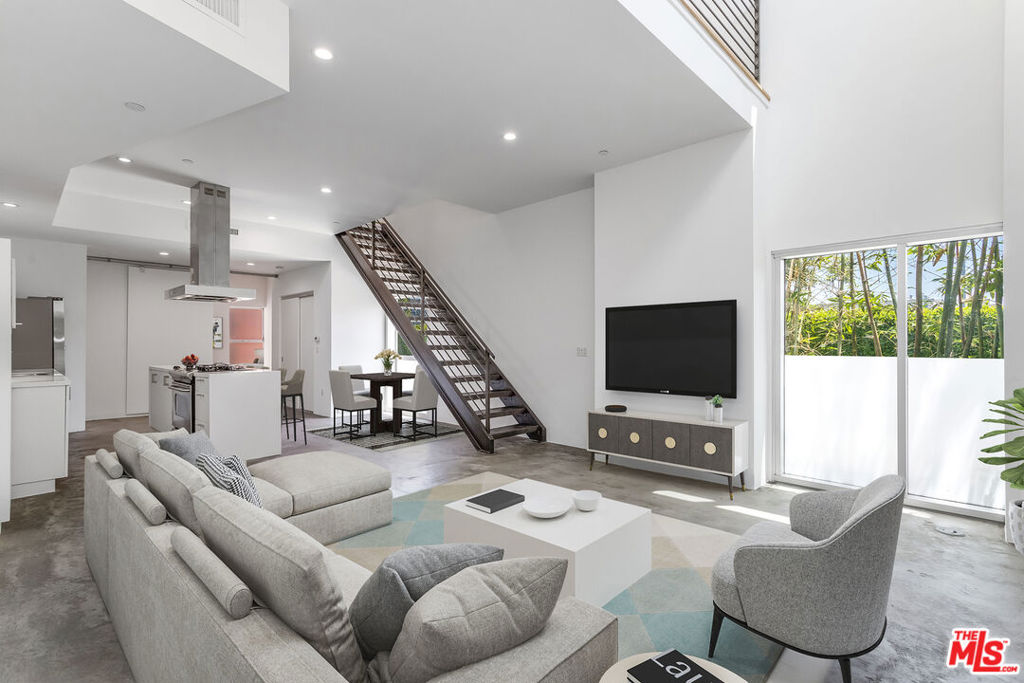 Award-winning architect Lorcan O'Herlihy, FAIA, designed the Wilcox Avenue Lofts to redefine urban living, and 17 years later, Loft #5 remains one of the best in the complex. Positioned on a prime corner with a direct ground-floor entrance, this two-story, 1,330sq.ft. unit offers two full bedrooms, two bathrooms, and a den/office that can serve as a third bedroom, complete with a barn door for privacy. South- and east-facing walls of glass flood the living, dining, and kitchen areas with natural light. The kitchen and bathrooms stay true to O'Herlihy's original aesthetic, with tasteful updates including a Samsung stainless-steel fridge and LED lighting. Additional features include newly-installed frosted sliding closet doors in both upstairs bedrooms. Gated and secure, the WA Lofts are well located near Larchmont, Gold's Gym, Hancock Park, and Paramount Studios; central yet removed from high-traffic zones. Sale includes two assigned tandem parking spaces and guest parking in a subterranean garage. HOA dues are $785 and include earthquake insurance.