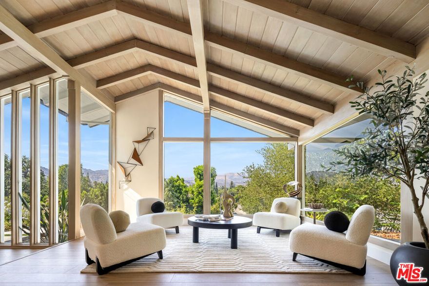 From the moment the automated gates open, The Sky Estate at 9425 Gierson feels less like a residence and more like a private retreat in the clouds. A sculpted drive winds past a detached four car garage and curated California modern landscaping of olive and willow trees, specimen succulents, and native cacti. As you ascend the ridge, the city fades away and the horizon opens wide. Inside, a dramatic living room with 12-foot ceilings and floor to ceiling glass frames panoramic mountain and valley vistas turning every sunset into part of the decor. Wide plank oak floors lead into an open dining area and chef's kitchen with Italian cabinetry, a quartz waterfall island, and a complete Thermador suite, designed for effortless entertaining and everyday comfort. The main level also offers a junior en-suite for guests or multigenerational living, a powder bath, mudroom, laundry, and a lounge with canyon views. Floating Brazilian stairs rise to two secondary bedrooms and a breathtaking primary suite, where mornings begin with sunrise over the ridgeline. The spa inspired bath showcases a freestanding tub, dual rain showers, and custom wardrobe storage. Outdoors, the estate unfolds like a hillside resort: a pool with built-in BBQ, a putting green, and a sky-deck with firepit capturing 270-degree city-light views. With nearly two acres of LARA-zoned land, the property also carries rare equestrian-friendly allowances an uncommon advantage in Los Angeles that expands the lifestyle possibilities of this private sanctuary. Thoughtfully engineered with dual-zone HVAC, tankless water heater, 400-amp service, EV charging, and Low-E glazing, The Sky Estate offers architectural presence, modern luxury, and a sense of escape ready to welcome its next chapter.