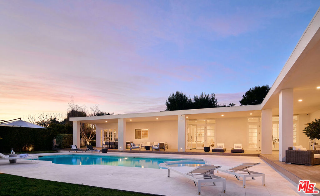 Located in the prestigious Trousdale Estates, this grand home showcases sophisticated living in prime Beverly Hills. Single storied, boasting 6,200 square feet of living, five bedrooms and seven bathrooms, on a large 20,000 square foot lot, all privately gated on the highly sought after Carla Ridge. An exclusive circular driveway leads you to the beautifully arched french doors, a domed foyer entrance, and soaring ceiling heights to complement the art walls and contemporary open floor plan. An elegant kitchen, breakfast nook, and formal dining room feature custom wooden cabinetry, an oversized island, marble countertops, top-of-the-line stainless steel appliances, and striking bay windows that bathe the rooms in calm natural sunlight. Open living spaces and wet bar, anchored by a floating fireplace, illuminate the backyard backdrop set ideally for indoor outdoor living and entertaining alike. Designed for resort style living, the primary suite features a custom walk-in closet, a marble bathroom of dual sinks, a sitting tub and shower, a traditional cozy seating area with a fireplace, and french doors opening to the backyard oasis. The grounds are nothing short of spectacular with impeccable landscaping, multiple lounge areas, outdoor dining, a pool, spa, ideally hedged for the utmost serenity and beauty. An architectural work of art offers quintessential Trousdale Estates living at its finest.