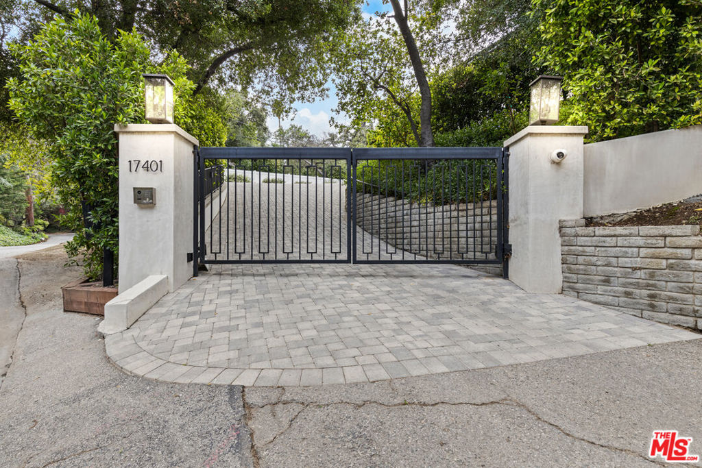 The home you've been waiting for in Encino! Welcome to a rare fusion of contemporary elegance and California warmth in this thoughtfully designed 5,400 sq ft, 6 Bedroom, 7 Bathroom estate. Situated on a beautifully flat and private gated lot surrounded by majestic oak trees, this one-of-a-kind home was crafted with custom finishes and timeless architect. From the moment you arrive, the home's presence is undeniable. A hand-laid cobblestone driveway sets the tone for the attention to detail you'll find throughout. Inside, natural light pours into open, airy living spaces that flow effortlessly offering the ideal setting for both quiet moments and entertaining. Lutron-controlled lighting on the windows let you tailor the ambiance and privacy. The foyer greets you with soaring ceilings extending into the formal living room with seamless indoor-outdoor access through Fleetwood sliding doors. The formal living room and family room are elegantly connected by a dual-sided, see-through fireplace adding warmth, ambiance, and a touch of luxury to both spaces. Host unforgettable dinner parties in the formal dining room, complete with a stunning custom glass wine display. The open-concept family room offers the ultimate everyday comfort with custom built-ins and effortless connection to the kitchen and access to outdoors. The gourmet eat-in kitchen is a chef's dream, equipped with premium Wolf and Thermador appliances, custom cabinetry, and an oversized island perfect for gathering and entertaining. The first level features three bedrooms, including a suite with Fleetwood doors that has direct access to the backyard pool area, perfect for guests, in-laws, or a gym. Upstairs, you'll find a versatile loft area and media room with Dolby Atmos surround sound for an immersive cinematic experience. The primary suite feels like a true retreat. French doors greet you at the entrance, opening to a serene sanctuary featuring dual walk-in closets, a cozy fireplace, and a spa-inspired bathroom with soaking tub, dual vanities, double shower, and a private water closet. Step out onto your own private balcony with an outdoor fireplace, an ideal space to begin your day with coffee or end your day in peace and luxury. Two additional upstairs bedrooms are generously sized and beautifully appointed. Step outside to a serene, private backyard with premium low-maintenance turf designed for sophisticated entertaining and relaxation. Experience elevated outdoor living with a peaceful fire pit area, resort style pool and spa, featuring a Baja shelf, outdoor kitchen and BBQ, ideal for weekend gatherings or quiet evening unwinds. The poolside cabana has a TV and full bathroom which could be converted into an ADU, offering even more flexibility. Cutting-edge smart home automation puts lighting, climate, security, and entertainment at your finger tips, integrated seamlessly into a home defined by luxury craftsmanship and high-end finishes throughout, sets this home apart from the ordinary. Located on a quiet, desirable street, this estate delivers comfort, style, and versatility in one of Encino's most coveted pockets. If you've been searching for something beyond the expected- Welcome home!