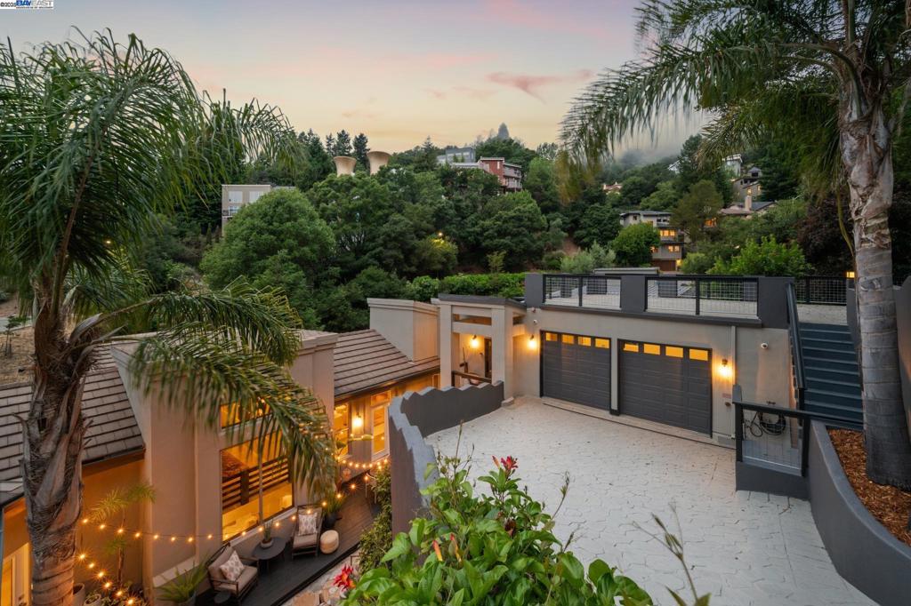 Live in sophisticated modern elegance in this extraordinary 4+BD/3.5BA contemporary with a touch of Balinese influence, privately and peacefully tucked into the Claremont Hills. Sunlight streams throughout the 4542 SQFT home from a multitude of picture windows that make the beautiful hills your backdrop. Entertain and relax under the great room’s cathedral ceiling, cozy up to its fireplace, or open the glass door to the patio for indoor/outdoor living. The heart of the home flows from an exquisite dining room to a fabulous eat-in kitchen, featuring two islands, an adjoining den with fireplace, and a small deck. Cook in your chef’s kitchen while family and friends gather around. Off to the side, find a guest room with a stylish ensuite bath and French doors to the patio. The main floor is complete with a powder room and another bedroom. Downstairs, another large den centers the bedrooms. On one side, two roomy bedrooms share a bath with dual vanity, while the private primary suite is on the other side. Enjoy a huge spa-like bath, custom walk-in closet and French doors to a deck. Ample parking and a secret path to the Transbay bus for easy commuting. Out your front door, explore miles of trails, BART, and Berkeley’s world class amenities.