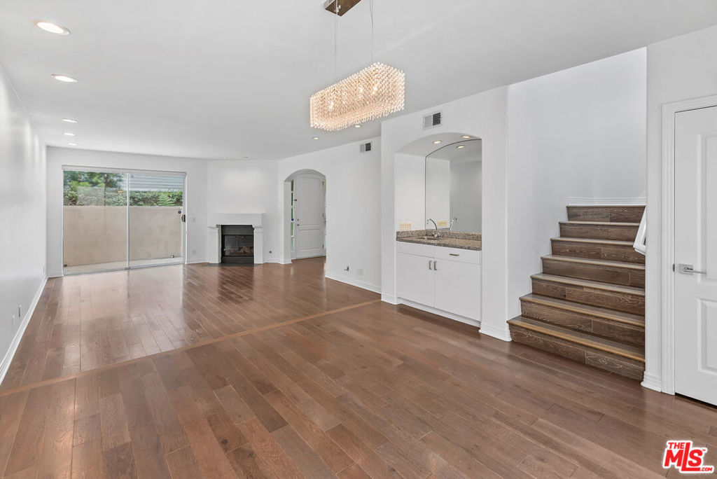 Experience contemporary living in this stylish two-story townhome, nestled within a coveted, gated community with secure access in a premier Westside location. Step through the foyer into expansive open-concept living and dining areas, complete with a powder room and wet barperfect for entertaining. The chef's kitchen impresses with stainless steel appliances, double ovens, a large center island, and granite countertops.Upstairs, soaring ceilings and skylights flood the den, staircase, and laundry room with natural light. The spacious primary suite features a cozy fireplace, private balcony, generous walk-in closet, and a spa-inspired bath with dual vanity. Two additional bedrooms each include walk-in closets, with one offering access to a private patio. A shared bathroom offers a dual vanity, soaking tub, and separate shower.The home boasts a sense of volume and scale throughout, with rich hardwood floors and recessed lighting. A private two-car garage with direct access and additional storage adds everyday convenience. Community amenities include a sparkling pool, spa, BBQ area, children's play zone, guest parking, and more. Ideally located near UCLA, Century City, Santa Monica, major freeways, and the vibrant dining scene on Sawtelle.