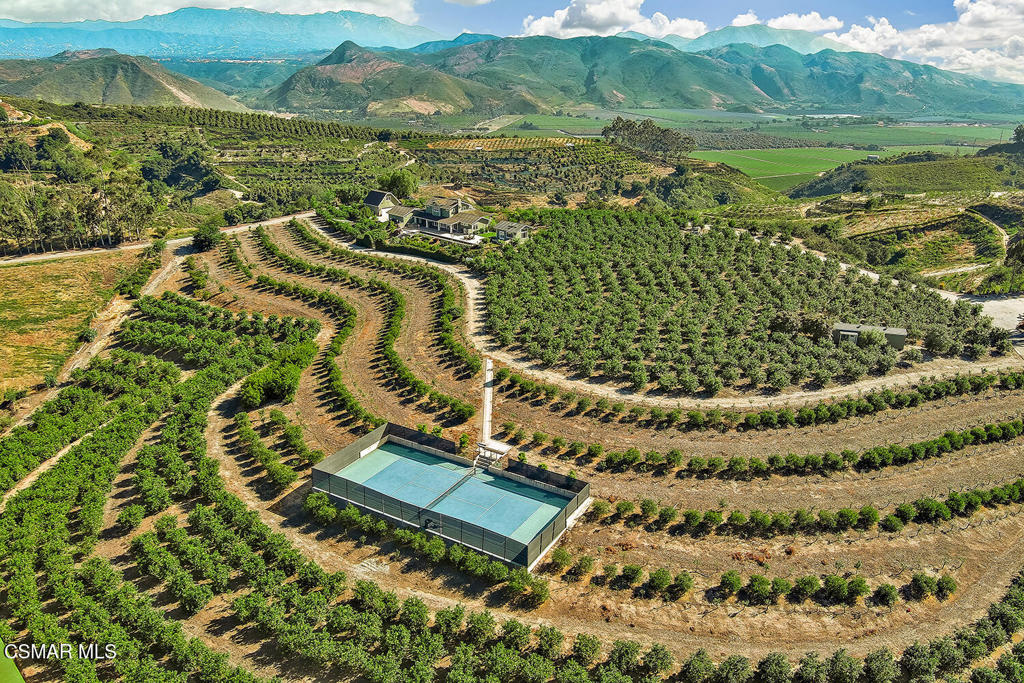 Ocean-View Lemon Orchard Estate with Income & Major Tax Savings! Perched atop the hills of Santa Rosa Valley with sweeping 360-degree views towards the Pacific Ocean, this 20.35 acre estate blends luxury living, agricultural income, and major property tax advantages due to the Williamson Act. Custom-built in 2009, the approx. 3,000 sf main residence was designed to embrace its natural surroundings and support a health-focused lifestyle. Inside, you'll find 3 bedrooms, 3.5 baths, an open-concept great room with fireplace, a spacious kitchen with island, a formal dining area, and a private office with built-ins and a coffee bar. The main-level primary suite offers spa-like comfort, while thoughtful upgrades include a whole-house water purification system, energy-efficient DC HVAC zones, and concrete Hardy-board siding with a 50-year metal roof. Outdoor amenities include a 75-foot lap pool with motorized cover, spa, built-in BBQ, and fire pit-- the perfect set up for entertaining.For added flexibility, the property features two detached guest units: a 410 sf studio above the barn/garage and a 450 sf garden studio--each with private entrances and kitchenettes. Together with the main home, there's garage parking for four cars. The professionally managed lemon orchard is under lease, generating $10,000 annually with no upkeep required from the owner. Additional features include mature avocado and tropical fruit trees, raised garden beds, a 2,000-gallon septic tank, and multiple storage and utility buildings. Energy-conscious upgrades include a 66-panel owned solar array, three Tesla batteries, an EV charger, and a new Wi-Fi-connected sauna. The home also boasts fireproof vents, sprinklers, hydrants, and a sound-insulated second floor. A regulation-size tennis court and fenced backyard complete this versatile estate.Located within a private gated enclave with no HOA fees, this property offers total privacy just minutes from town and the coast. Combining sustainable living, long-term income, and dramatic tax savings, 10255 Presilla Road is a rare opportunity to own a truly self-sufficient California coastal farm and luxury estate. Schedule your private showing today!