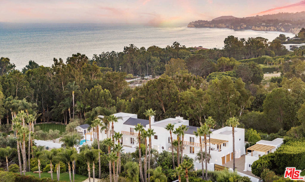 This new, completely custom Malibu estate is a modern Santorini-inspired masterpiece. Reimagined by financier Daniel Starr in collaboration with Saffron Case Homes, the extensive remodel blends Californias casual elegance with Greek-resort luxury. Behind two private gates, discover a pristine palm-lined property with mature olive and fruit trees. In the main residence, impeccable craftsmanship greets you at every turn. Enjoy a bright living room with 30-foot ceilings, a gourmet kitchen with Caeserstone countertops, tadelakt bathrooms, an office, library and gym. Designed for effortless entertainment, the home features an audio system, theater, bar, wine cellar and game room. Dazzling ocean views and a lavish primary suite await you on the second floor. Explore the grounds designed by Brown and Associates Landscape Co., with paths, a pool/spa, volleyball court, remodeled guest house and 3-car garage. Moments from Escondido Beach and Geoffreys Restaurant, this tranquil and private estate feels a world away.
