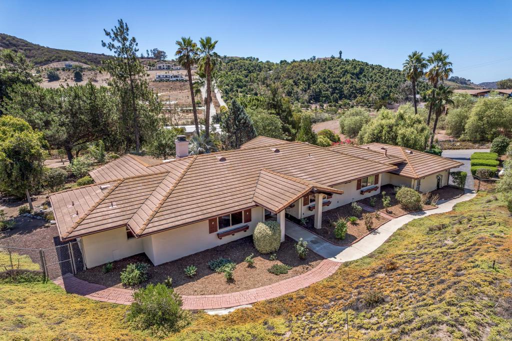 Welcome to a luxurious single-level retreat in serene Vista. Set on nearly 2.7 acres of beautifully landscaped grounds, this recently remodeled Spanish-style home offers 2,541 square feet of living space, four bedrooms, and two and a half baths. Arched doorways and charming design details create timeless character, while modern upgrades provide comfort and convenience. Step inside to a bright, open living area where natural light dances across rich terracotta-style floors. The dining space flows seamlessly into the kitchen, where white oak lower cabinetry grounds the design and crisp white uppers keep the room light and inviting. A skylight, stainless-steel appliances, farmhouse sink, and generous walk-in pantry complete this chef-ready space. A cozy breakfast nook overlooks the patio and offers a quiet spot to enjoy morning coffee. The primary suite is a private retreat with patio access, a spa-inspired bath featuring a soaking tub with views, a standalone shower, dual vanities, dedicated makeup counter, and a spacious custom closet. Three additional bedrooms are light-filled and flexible for guests, work, or hobbies. Outdoors, mature landscaping frames tranquil patios and meandering stone paths. A detached workshop/shed supports creative projects, and a versatile multi-use enclosure—once an aviary—opens up countless possibilities. With nearly three acres, the grounds easily accommodate an ADU, pool, or horses, offering room for your vision to grow. Nestled in a peaceful neighborhood, the property combines country serenity with quick access to shopping, dining, and recreation. Wide-open vistas and a welcoming community atmosphere create the perfect balance of privacy and ease. Discover how captivating your next chapter can be. Schedule a private tour today and experience the possibilities for yourself.