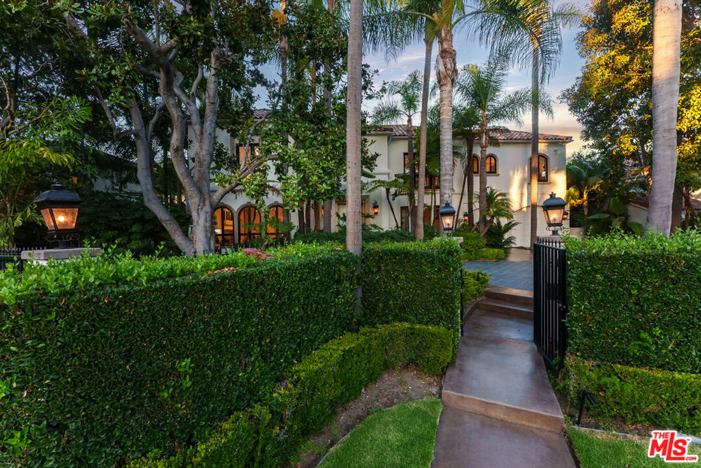 Presenting The Bedford Estate, a newly refreshed Mediterranean masterpiece in the coveted Flats of Beverly Hills. Gated and private, the striking white exterior with black trim is framed by a circular driveway, leading to an elegantly designed two-story residence of approximately 11,000 square feet on a half-acre of pristine grounds. A dramatic two-story foyer with a sweeping staircase introduces the formal living room, dining room, office, and an exceptional family room with floor-to-ceiling French doors that open seamlessly to the backyard. Wide-plank white oak floors, soaring ceilings, expansive windows, multiple fireplaces, and abundant natural light create a warm yet grand atmosphere. The chef's kitchen is a culinary dream, featuring skylights, a large center island, and an expansive informal dining area that also opens to the outdoors. The backyard is a private oasis, offering multiple seating and lounging areas, an inviting pool, and a beautifully landscaped grassy yard. A separate pool house complete with a bath provides the perfect retreat or entertainment space. Upstairs, the primary suite is truly exceptional, showcasing vaulted beamed ceilings, floor-to-ceiling windows, a fireplace, and two luxurious spa-style bathrooms each with a seating area and boutique-sized closets. Three additional upstairs ensuite bedrooms offer generous proportions, high ceilings, and refined finishes. A service bedroom is conveniently located downstairs near the back staircase. Completing the estate are two attached garages plus two additional garages accessed from the alley. This is truly a one-of-a-kind home in a one-of-a-kind Beverly Hills location.