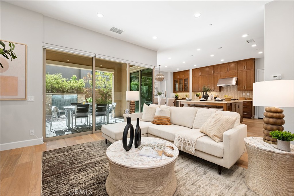 This exquisite custom-designed modern residence is nestled within the prestigious guard-gated community of The Groves at Orchard Hills in Irvine, one of the city’s most coveted neighborhoods. Thoughtfully crafted with elegance and comfort in mind, the home showcases a stunning open floor plan filled with luxurious upgrades and timeless finishes throughout. The residence offers 4 spacious bedrooms, 4.5 bathrooms, a downstairs executive office, and an expansive upstairs loft, creating versatile living spaces for both work and leisure. The inviting family and dining rooms seamlessly connect to the gourmet chef’s kitchen, featuring premium stainless-steel appliances, a generous walk-in pantry, sleek quartz countertops, and an oversized island with breakfast bar seating—perfect for casual dining and entertaining. On the main floor, a private guest suite with full bath provides comfort for visitors, while the executive office offers the ideal setting for work-from-home professionals. Through the expansive sliding glass doors, the heart of the home extends into the backyard oasis. Here you’ll discover a beautiful California Room with elegant stone flooring, ideal for year-round gatherings and relaxation. The landscaped backyard is enhanced by a charming water fountain, creating a tranquil ambiance for outdoor living. Upstairs, the resort-inspired primary suite boasts a private balcony, spa-like bath with soaking tub and walk-in shower, dual vanities, and an oversized walk-in closet. Two additional bedrooms, each with access to full baths, plus a well-appointed laundry room with abundant cabinetry, complete the upper level. Notable features include engineered hardwood flooring throughout, plantation shutters, recessed lighting, custom draperies, dual-pane windows, and a tankless water heater for modern convenience and efficiency. Residents of The Groves enjoy exclusive access to community amenities, including parks, pools, spa, scenic walking trails, and sports courts. Perfectly located near top-rated schools, fine dining, shopping centers, and major freeways, this turnkey home is move-in ready and truly a dream come true.