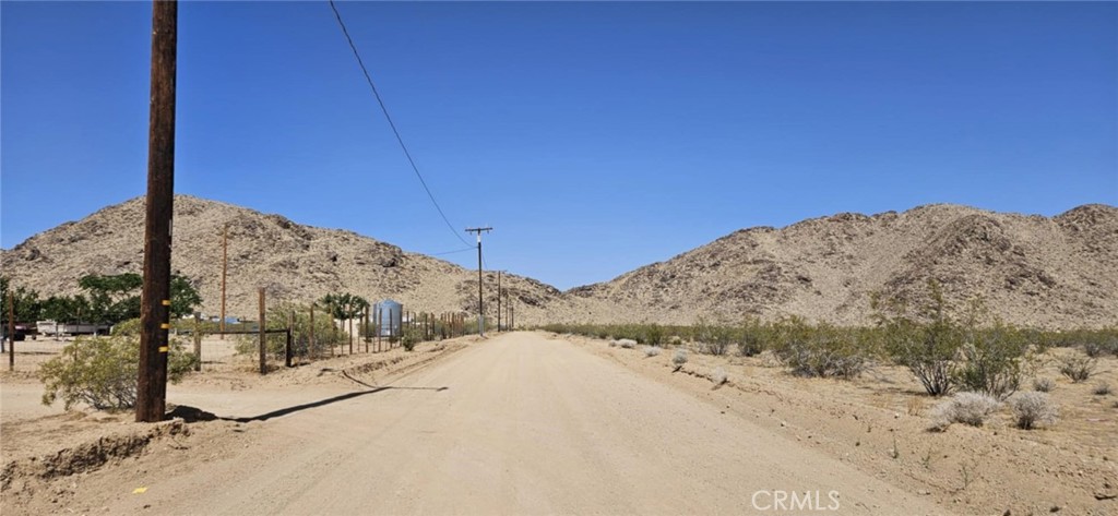 Almost 2 acres of level land with power access for sale, near paved HWY 247! There is good dirt road access via Chrysolite St. This parcel is situated in a residential area with only a few neighbors around. The lot offers a rural feel with beautiful mountain views, all while being just a short drive to the center of town. Whether you're looking to build, camp, or invest, this is a great opportunity in the high desert! Come out and take a look before someone else does! Invest today! APN: 0453-271-01-0000. Latitude:34.579049, Longitude:-116.973134.