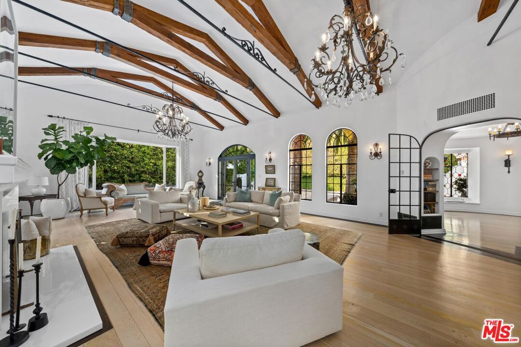 Nestled in the Pacific Palisades' most coveted area, the Riviera, stands this stunning iconic Hollywood Spanish celebrity compound. Completely remodeled/restored and updated to perfection, this residence exemplifies Hollywood 20's opulence and architectural detail combined with the latest modern luxuries. Securely tucked behind gates and tall hedges, the estate features a grand 10 car motor court flanked by two majestic Canary Island date palms perfectly framing the front entrance. Every detail throughout the home has been thoughtfully curated, from ironwork and arched casement windows to wood ceiling beams, stained glass, and handcrafted tile work. A grand foyer, featuring a custom fountain beside the stairwell, warmly welcomes you into the main living spaces. The grand formal living room boasts vaulted ceilings, oversized period windows, anchored by an oversized fireplace, seamlessly flowing into the character-rich dining room adorned with stained glass accents and wainscoting. The kitchen is a true masterpiece, conveniently accessible from the dining room and foyer. It features two Miele refrigerators, a top-of-the-line Wolf range + oven, marble countertops, and an inviting breakfast room that opens onto the patio. Entertaining is effortless with a movie/screening room featuring an ultra HD projector, adjacent to two guest bedrooms on the main floor. Upstairs, you'll find three additional bedrooms and a well-appointed office. The office, unique with its curved architecture and stained glass windows, is easily accessible from the primary suite. The primary suite is a sanctuary with vaulted ceilings, a fireplace, a balcony overlooking the lush landscaping, an adjoining fitness center, and a resort-style bathroom. Highlights include marble countertops, a freestanding tub, designer sconces, and two ultra luxurious walk-in closets. Outside, multiple spaces for relaxation and entertaining await, including a flat grassy area, a large pool, and a jacuzzi, all surrounded by mature, manicured hedges for ultimate privacy. This Spanish-style estate, blending timeless Old Hollywood charm with modern luxury, offers a rare opportunity to own a piece of the Riviera's prestigious history, perfect for those seeking a lifestyle of functionality and privacy.