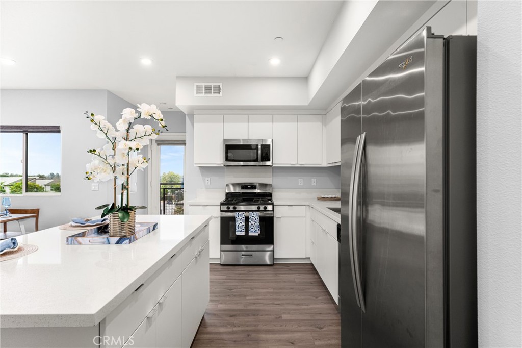 Welcome to your modern and stylish condo in the heart of Brea! Unit #307 is located on the top (third) floor—please note, there is no elevator. This beautifully updated home features an open floor plan flooded with natural light, an elegant living room, a dining area that leads to a private balcony, and a sleek white kitchen complete with stainless steel appliances and quartz countertops.
The spacious primary suite offers a walk-in closet and a luxurious en-suite bathroom. A second bedroom and full bath provide flexible living space for guests, a home office, or additional family needs. Additional highlights include a private 2-car tandem garage and the added benefit of no neighbors above. Enjoy resort-style community amenities including landscaped parks, a children’s playground and splash pad, BBQ area, and cozy fire pit. All this, just minutes from downtown Brea, shopping, dining, top-rated schools, and easy freeway access.
Don’t miss this rare opportunity to own one of the best values in Brea—schedule your tour today!