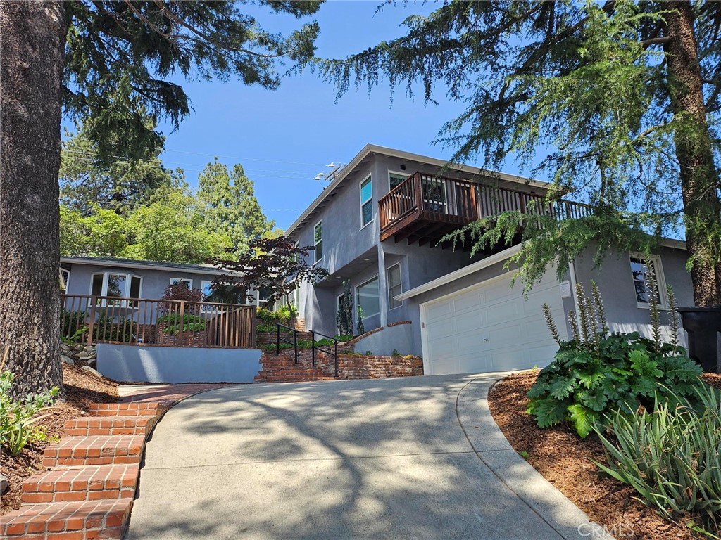 Stunning Remodeled Traditional-Modern View Home in La Crescenta. Welcome to this luxurious, fully remodeled home that beautifully blends traditional charm with modern elegance, nestled in the desirable hills of La Crescenta. This energy-efficient property features solar energy system with a whole-home backup battery. Step into a light-filled, two-story entryway that leads into a warm and inviting living room with a cozy fireplace. European wide-plank hardwood floors, Milgard dual-pane windows, and crisp white shaker doors and cabinets create a bright, sophisticated atmosphere throughout. The gourmet kitchen is a true showpiece, boasting quartz countertops, light blue glass subway tile backsplash, Bosch stainless steel appliances, a center island with sit-up bar, and an adjacent pantry/laundry room. Flowing seamlessly into the formal dining area, this open-concept space is flanked by a wall of windows showcasing breathtaking views of the Verdugo Mountains. A central hallway with built-in cabinetry leads to two spacious main-level bedrooms, one of which offers a private patio retreat. Both rooms share a designer bathroom with a custom dual-sink vanity and a large walk-in shower enclosed in elegant glass. Upstairs, the private primary suite offers a serene sanctuary, complete with a walk-in closet, mountain and treetop views from multiple windows, and a spa-inspired bathroom featuring dual vanities and a deep soaking tub/shower combo. Step outside onto your own redwood deck—ideal for morning coffee or evening relaxation. The home’s versatile lower level includes a separate-entry studio or fourth bedroom, complete with a built-in kitchenette, bathroom with walk-in shower, and flexible space perfect for a home office, guest suite, or family room. Modern upgrades include updated electrical with new panel, copper plumbing, HVAC ducting, recessed lighting, 220V pre-wiring for EV charging, interior and exterior lighting, redwood deck, new garage roof, and rain gutters. Outside, enjoy lush, professionally landscaped gardens and multiple patio areas—perfect for al fresco dining, entertaining, or simply taking in the stunning natural surroundings. Located within the award-winning California Distinguished and Blue Ribbon La Crescenta school district.