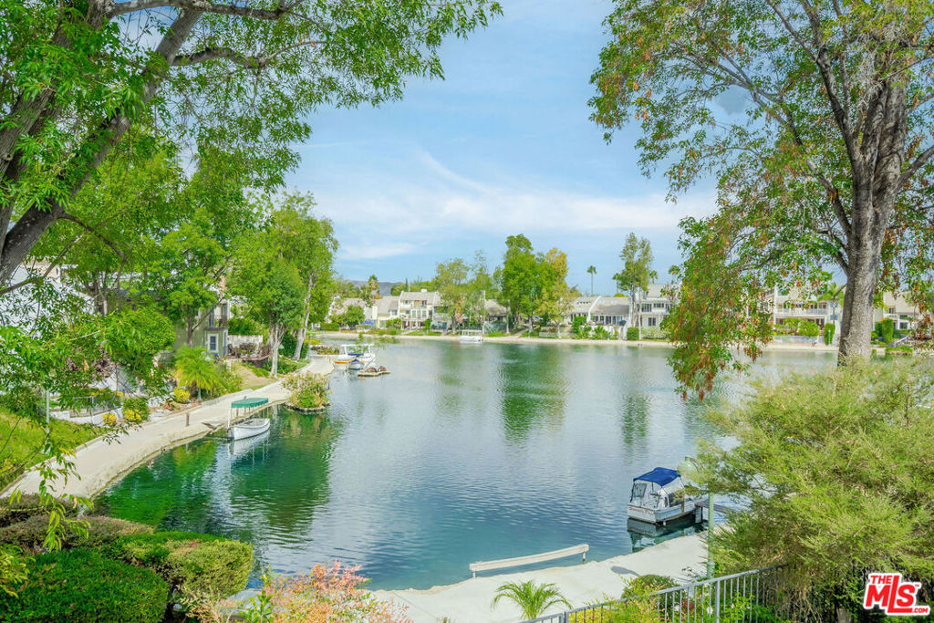 Experience stunning lake views from nearly every room in this beautiful lakefront home! Nestled on a cul-de-sac, this bright and airy 3-bedroom, 3-bath home boasts over 2,700 square feet of open living space. Extensively remodeled and move-in ready! As you enter, you'll be captivated by the lake views in the spacious living room, which features high ceilings, double doors leading to a large outdoor deck, and a  fireplace. The modern kitchen includes an oversized wood island, brand-new stainless steel appliances, a walk-in pantry, and convenient access to the deck-perfect for enjoying your morning coffee while taking in the vibrant lake scenery. The room on the main level can be used as either a bedroom or den, offering plenty of closet space and direct access to the front porch. The primary bedroom, located on the lower level, features a fireplace, direct access to the patio, and two private walk-in closets with built-ins.  An additional room on this level, perfect for a gym or yoga studio, offers you the freedom to personalize your space. The top floor features a versatile loft that can adapt to your needs, whether it's an additional bedroom or productive office complete with a built-in desk, ample storage closet, and a bathroom with a shower. The outdoor patio space is perfect for entertaining and relaxing, and you're  just steps away from the lakes walking path- the loveliest walk around! This property also includes a generously sized two-car garage with storage racks and an additional storage room. The Homeowners Association (HOA) grants access to Calabasas Lake and provides 24/7 vehicle patrol throughout Calabasas Park. All this is located in the award-winning Las Virgenes School District and in close proximity to the bustling Calabasas Commons and the Calabasas Tennis and Swim Club, offering a lifestyle of convenience and leisure.