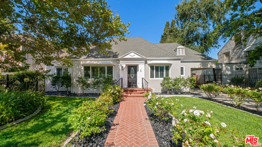 Charming Traditional Home in Prime Toluca Lake, this beautifully maintained residence blends timeless elegance with modern comfort. From the moment you step inside, you're greeted by a bright, open-concept living space featuring vaulted ceilings with exposed beams, rich wood floors, and abundant natural light streaming through plantation shutters. The spacious living room is anchored by a classic white brick fireplace, perfect for cozy evenings. The flow is seamless into a formal dining room and a thoughtfully designed kitchen with ample storage. The primary suite offers a private retreat with generous closet space and an en-suite bath, while two additional bedrooms provide flexibility for family, guests, or a home office. Outside, enjoy a tranquil, landscaped backyard ideal for entertaining or relaxing by the pool. A fully built-out guest house boasts a living room, kitchenette, bedroom, and bathroom, ideal for hosting guests or use as a creative studio/work-from-home office. Additional storage on the side of the guest house only adds to the convenience of the property. This home is a rare opportunity to own in one of LA's most desirable neighborhoods.