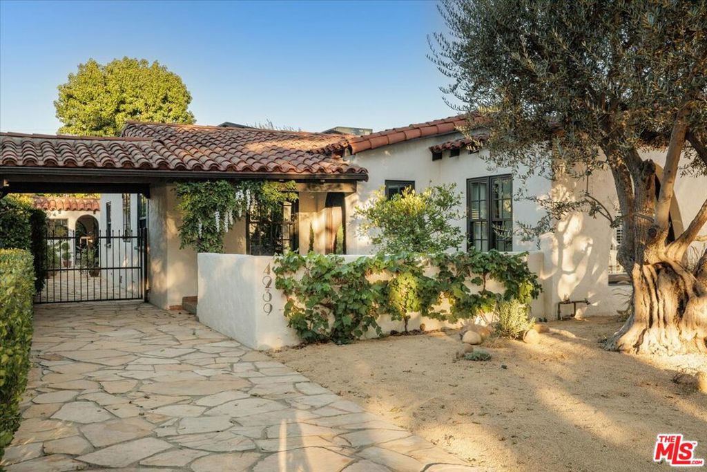 Spanish elegance, Art Deco glamour, and exquisite craftsmanship come together in this three bedroom, two bath property situated on a tree-lined street in Atwater Village. An arched doorway welcomes you into the sunlit living room blending old world charm with a stylish flair. Beyond the intimate dining space lies the heart of the home, a kitchen that is both a showpiece and workspace. Calacatta Borghini and Nero countertops gleam upon heated marble mosaic floors, while a custom Ilve hybrid range with dual ovens anchors the room. A Liebherr Monolith refrigerator, freezer, and wine fridge provide professional-grade storage, while handmade reeded mahogany cabinetry is illuminated by a dazzling crystal chandelier, creating a space that is as visually stunning as it is expertly equipped. The bathroom is a serene retreat with heated marble floors, a steam shower, and a Penhaglion clawfoot tub with custom finishes. A bespoke mahogany vanity pairs with a Nero Marquita wall tile mosaic, meticulously inlaid with brass, while DXV fixtures throughout lend a refined finish. Together, these elements create a space that feels both restorative and artfully designed. Both bedrooms are inviting and offer charm, privacy, and views of the landscaped grounds. Original details, including restored hardwood floors and a crystal chandelier, a working fireplace with its preserved hearth, are elevated by gold leaf ceilings, hand-painted wallpaper, and restored stucco inside and out. The ADU extends the homes' versatility with solid oak floors, 1920's-style tile, and Pinky's iron doors and windows creating an ideal guest suite, studio or income property. Outdoors, the grounds unfold like a private oasis with hand-carved Balinese volcanic stone statues, a serene pond, lush fruit trees and mature olive trees. Custom Art Deco pillars frame the landscape, while a fire pit, buckskin flagstone driveway, and EV charger add both style and practicality. Rarely does a home offer a lifestyle of artistry, comfort, and timeless design.