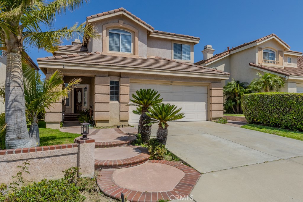 Welcome to 981 S Dylan Way, a view home located on a quiet cul-de-sac in one of the most desirable neighborhoods in Anaheim Hills. Enjoy peekaboo city light and mountain top views from the backyard and upstairs balcony, all within the highly rated Orange Unified School District.
Upon entering, you’re greeted with two-story high ceilings and abundant natural light flowing through the living room. To the right, you’ll find the dining area, and straight ahead is the family room with a granite fireplace, built-in JBL speakers, and recessed lighting. The family room connects seamlessly to the kitchen, which features granite countertops, a stainless steel Viking range, peninsula bar seating, and a charming bay window that fills the space with natural light and showcases the backyard views.
Downstairs also includes a convenient half bathroom, an interior laundry room with upper cabinets, and direct access to the attached two-car garage with built-in storage cabinets. The flooring throughout the downstairs is stone travertine tile.
Upstairs, the spacious primary suite offers vaulted ceilings and spectacular views from its private balcony. The primary bathroom includes dual sinks, a soaking Jacuzzi tub, a walk-in tiled shower, a large walk-in closet, and a private toilet room. Down the hall, the full guest bathroom features two separate vanity sinks and a private tub and shower area. Three additional bedrooms are located at the end of the hallway, each with mirrored closet doors, offering privacy from the primary suite.
This home is located in the Orange Unified School District, with access to highly rated schools including Canyon Rim Elementary, El Rancho Charter Middle, and Canyon High School. Shopping, restaurants, and parks are just minutes away, making this a rare lease opportunity in a prime Anaheim Hills location.