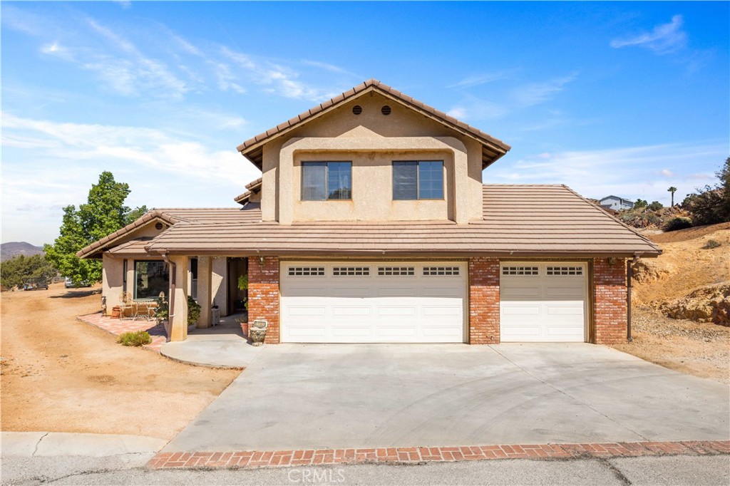 Charming two-story home located at the end of a cul-de-sac in the desirable Country Way Estates neighborhood in the small town of Acton! Panoramic views take your breath away as you embark upon this 4 Bed, 3 Bath, 2,476 sqft home on 2.14 Acres. Great layout with all the right spaces: entertain in the formal Dining and Living rooms; relax in the cozy Family Room with fireplace; or host gatherings in the well-appointed Kitchen. The kitchen is spacious, with classic tile counters, oak cabinets, a sweet garden window, and abundant storage, including a walk-in pantry. It is adjacent to the breakfast nook, which flows seamlessly into the Family Room. There is access to the back patio from both the dining and family rooms, extending entertaining space. All 4 bedrooms are on the second floor, including the Primary Bedroom, which is a retreat, with its own private balcony and attached bathroom with separate shower, soaking tub, dual sinks, plus a walk-in closet. Three more bedrooms and a full bathroom will accommodate a large family or guests. An indoor laundry room is a welcome convenience providing extra storage and has direct access to the 3-Car garage. The property has the perfect blend of space with with a cross-fenced backyard and enough room for RV parking or animals. Easy country living on paved roads with county water, natural gas and close access to schools, the park, shopping and the freeway.