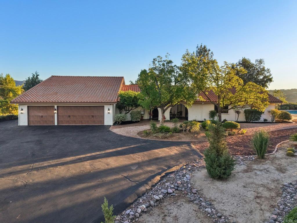 Stunning remodeled 4-bedroom Palo Verde Ranch estate on 2 acres with sweeping lake views, breathtaking sunsets, and a sparkling pool and spa! Tranquil courtyard and stately double doors open into a modern Spanish-style home with vaulted ceilings, exposed beams, and an inviting open-concept layout. The chef’s kitchen boasts a large gas island, peninsula with seating, built-in oven with warming drawer, walk-in pantry, and stainless appliances. Entertainer’s dream backyard has panoramic views, a resort-style pool and spa with cascading waterfall, and a cozy fire pit for evenings under the stars. The expansive primary suite features patio access, a private yard, and spa-like bath with soaking tub framed by lakeview windows, tiled walk-in shower, dual sinks, makeup vanity, and walk-in closet. Two additional bedrooms share an updated bath with pool access, while the fourth bedroom doubles as an office with fireplace, built-ins, and French doors to the courtyard. Upstairs, bonus loft offers a grand entertaining space with fireplace, bar, and lakeview balcony. A 3-car garage with epoxy floors and cabinetry provides abundant storage. This premium estate offers true resort-style living in Alpine’s coveted Palo Verde Ranch. HOA amenities include a clubhouse with meeting/dance room, kitchen, wet bar, sauna, fitness room, pool table, and lakeview patio. Residents enjoy two private lakes: the 50+ acre Big Lake for swimming, fishing, sailing, kayaking, paddleboarding, and electric boating, and the Little Lake with riding ring, tennis, basketball, pavilion with BBQs, playground, and sandy beach. Equestrian and outdoor enthusiasts will love the sand volleyball, badminton, horseshoes, and miles of private riding, hiking, and biking trails connecting to Cleveland National Forest and the Pacific Crest Trail. Seasonal events include fishing tournaments, summer picnics, Trunk-or-Treat, tree-lighting, and New Year’s Eve parties—all for just $152/mo HOA. Don’t miss this rare opportunity!