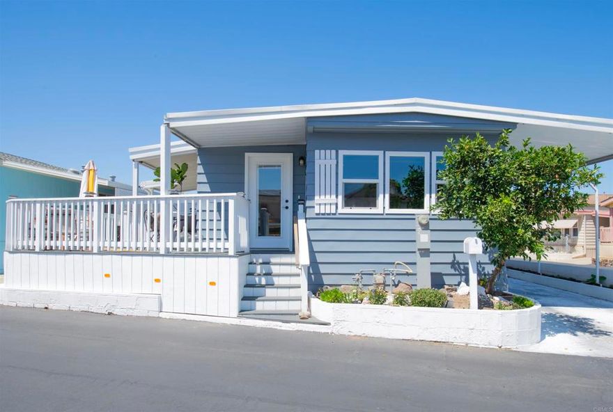 This reimagined home brings indoor and outdoor living together; this is a one-of-a-kind property that will not disappoint.  A total of 1,084 square feet (884 sq ft with an attached 200 sq ft sunroom), you get ample space for this 2 bedroom, 2 bath with a bonus den/utility room.  Located in San Luis Rey Homes.  This is a Resident OWNED 55 + Community, land ownership is involved.  The HOA fee is $175/Mo and includes trash, sewer, water & park maintenance.  Sit on the trex wrap around deck as you enjoy the cool breezes for one of your many outdoor spaces.  This corner lot gives you space to relax outside, plant and maintain a garden, or enjoy an evening fire on the patio.  Then when it's ready to go in you will be welcomed by hard surface flooring throughout, granite countertops, dual paned vinyl windows, newer appliances, recently installed walk in shower and all the finishing touches that make this place special.  This is the one you have been waiting for, don't let this opportunity pass you by.