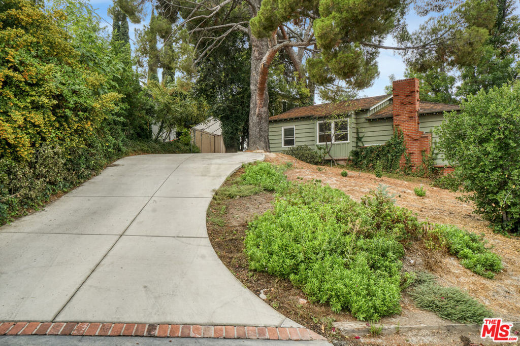 Tucked away in the highly desirable Woodland Hills South, within the private and picturesque Venido/Maycott loop, this residence offers the rare feeling of a tranquil cabin retreat while being just moments from city conveniences. Surrounded by lush greenery and mature trees, the property exudes privacy, serenity, and timeless charm.The home welcomes you with warm architectural details, including wood-beamed ceilings and a classic brick fireplace that anchor the main living spaces with character and comfort. Large windows frame sweeping canyon and city views, bathing the interiors in natural light. The open chef's kitchen is designed for both culinary creativity and connection, seamlessly flowing into inviting living and dining areas.Step outside to a sunlit patio that invites you to savor morning coffee, host gatherings, or simply unwind while taking in the peaceful backdrop of nature. Mature landscaping enhances the grounds, creating a sense of being immersed in your own private retreat.Adding to its versatility, the property includes a fully permitted ADU with its own address, 22458, currently occupied on a month-to-month basis. This space can be delivered with the tenant in place, offering immediate rental income, or delivered vacant for use as a guesthouse, home office, or private studio.Additional highlights include a two-car garage, ample driveway parking, and a location that strikes the perfect balance between seclusion and accessibility. Just minutes from Topanga Canyon, Ventura Boulevard, and local parks, this home captures the essence of California living: peaceful, private, and endlessly inviting.A rare opportunity to own a home that feels worlds away yet right at the heart of Woodland Hills South. Feel free to park in the driveway when visiting.