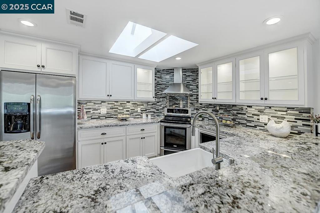 Rare Opportunity to own the finest expression of luxury living with exceptional collection of premium features and thoughtfully curated design beyond all others delivering a beautiful view of rolling hills and is bathed with lots of natural light. This home was distinctively reconfigured to showcase the ultimate California lifestyle with an open concept design. The heart of the home is the sprawling kitchen for the culinary minded chef appointed with high-end professional appliances, large peninsula with expanded farm sink surrounded by custom solid wood cabinetry, granite counter surfaces and glass mosaic backsplash. Relaxing living room offers an artfully framed electric fireplace with pulsating ember bed and flames. The features of this home is endless with large walk-in shower, oversized illuminating skylights, recessed lighting, coffered ceilings, lots of built-in cabinetry, convenient stack washer & dryer, dual pane windows, custom window coverings, designer carpet, mirrored closet doors, newer Lennox high-end HVAC system, newer plumbing & copper wiring & newer electrical panel with carport and storage closet just steps away and lots of guest parking nearby. Everything about this home is more than you could have dreamed for; a home you will enjoy coming home to.