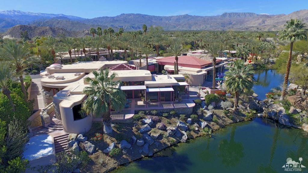 This timeless desert contemporary designed estate, set upon elevated lakeside location that spans three and one-half lots within the Desert Homes enclave. Lovingly maintained and cherished by its owners, this home is being offered at a remarkable savings. The sprawling single story home is situated for maximum light exposure while offering scenic views of the landscaped waterfalls, meandering lakes and a lazy lagoon, often visited by the desert's feathered friends. Beyond its remarkable location within The Vintage Club, its intriguing blueprint provides for grand-scale entertaining. Structures include the main residence with master suite and two guest rooms, a entertainment pavilion with a guest house featuring two bedrooms and two baths, and a dwelling that includes two guest rooms for staff or over-flow guests. Tremendous outdoor amusement areas, plus 20+ car garage.