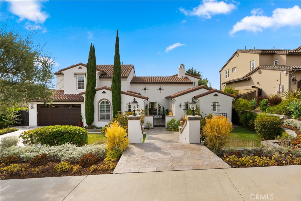 Blending timeless Spanish and Mediterranean influences, this residence is perched atop a ridge in the prestigious gated community of Rancho Madrina, showcasing panoramic views of the San Juan Capistrano hills, the historic Mission, and Marbella Golf Course. One of the community’s most sought-after floor plans, it features an oversized main-level primary suite thoughtfully positioned in its own private wing, with a versatile upstairs loft ideal for an office, gym, or lounge. A gated front courtyard framed by manicured landscaping sets the stage for refined craftsmanship throughout, where soaring beamed ceilings, a dramatic fireplace, glass doors, hardwood floors, crown molding, solid core doors, and custom built-ins define the great room and interior spaces. The gourmet kitchen boasts granite countertops, recently updated JennAir appliances, a beverage station, and spacious pantry, while the entertainer’s backyard offers a custom pool with waterfall features, spa, built-in BBQ, fire pit, and surround sound extending indoors and out. Additional highlights include a private office, dual-level laundry, upgraded HVAC, a 3-car tandem garage with epoxy flooring and garage doors replacement, epoxy-coated pipes, and freshly painted exterior—Ideally located near historic Downtown San Juan Capistrano, with easy access to Orange County’s beaches, parks, shopping, and major highways.