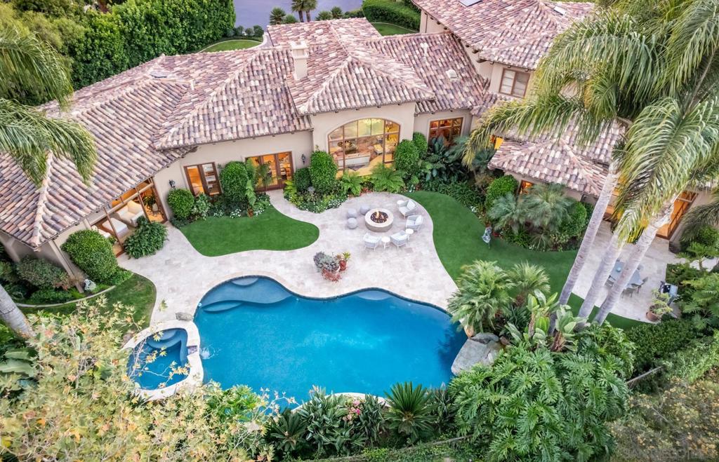 Welcome to 16404 Avenida Cuesta Del Sol, nestled in the prestigious enclave of Rancho Santa Fe's Fairbanks Ranch. This distinguished residence, crafted by renowned builder Danny Hampel in 2004, offers unparalleled luxury ranch living. A dramatic entry unfolds as you approach the circular driveway, showcasing remarkable curb appeal at the end of a serene cul-de-sac. Spanning an impressive 7,326 sf, this home lives like a single-level estate, featuring five spacious bedrooms, five and a half opulent bathrooms, an executive office, and a bonus room, all within an exceptional floorplan designed for both comfort and sophistication. Step outside to discover beautifully manicured, low-maintenance grounds that offer breathtaking views and a private outdoor oasis. The gorgeous pool and spa are perfect for relaxation, while the outdoor dining area and fire pit cater to outdoor entertainment and enjoyment. This estate is a testament to luxury living, offering a harmonious blend of elegance, comfort, privacy, and amenities, ideally located close to schools, shopping, dining, and more. The entry level features a grand foyer, paired with a formal living and dining room offering elegant settings for entertaining, while the large family room, adorned with exposed Douglas fir beams, seamlessly connects to the kitchen. The kitchen boasts a center island with an eat-in bar, stunning Taj Mahal countertops, exceptional custom cabinetry and high-end appliances, complemented by a butler's pantry and casual dining room. The Primary Suite offers a private haven with beautiful views and access to the outdoors, complete with a bonus room ideal for a gym or secondary office. This level also includes an executive office and two additional bedrooms with ensuite baths and an oversized powder room. Completing this level is the four-car garage and laundry room. Ascending the dramatic staircase to the second level, you'll find two expansive bedroom suites, one of which is currently positioned a media room, making it the perfect private guest quarters. Ascending the dramatic staircase to the second level, you'll find two expansive bedroom suites, one of which is currently positioned as a media room, making it the perfect private guest quarters. This level also features a seating area adorned with outfitted bookshelves, cabinetry, and storage. Living in Fairbanks Ranch offers residents exclusive access to a guard-gated community with 75 acres of common area. Enjoy the serene lake with opportunities for fishing and paddle boating, a clubhouse for social gatherings, and tennis and pickleball courts. The community also features an equestrian center, a private park, and scenic walking trails, enhancing the lifestyle experience.