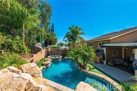 Canyon Lake Entertainer’s Dream with Pool & Paid Solar! This stunning 4-bedroom, 3-bath pool home offers an oversized 9-foot-deep saltwater pool with spa, waterfall, and multiple outdoor entertaining areas. The backyard is a showstopper with covered alumawood patio, built-in brick cooking station, firepit table, and low-maintenance artificial turf front and back. Fully paid-off solar keeps utilities low! Inside, enjoy two fireplaces, crown molding, plantation shutters, and hardwood floors! The spacious primary suite features a private deck, walk-in closet, dual vanities, and peek-a-boo views. A downstairs bedroom with en-suite bath makes a perfect guest or second primary suite. Extra perks: newer windows, whole-house fan, large laundry room, abundant storage, and oversized garage. All in the sought-after gated community of Canyon Lake with boating, golf, equestrian center, and more!