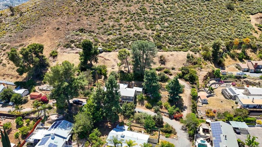 Awesome panoramic views from this 2 parcel  2 acre property.  Home sits on apx 1 acre of land, separate 1 acre above the house.  Fruit trees, avocado trees and garden areas.  Home needs some TLC and your ideas for making it your own peaceful paradise.  Check with the county as to adding additional units or building on the upper lot.  Located at the end of Taia lane, public sewer and water on property with home.