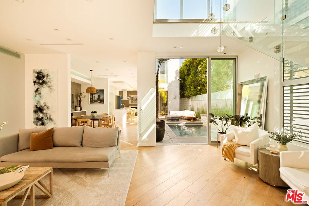 When a modern architectural home is merged with the comforts of Venice Beach living, you'll find 936 Milwood a perfect blend of contemporary living and an ideal location. Floor-to-ceiling sliding glass doors seamlessly integrate indoor-outdoor living - flowing from the sparkling pool right into a living level, rich and warm with clean lines, hardwood floors, and thoughtful finishes. The open floor plan invites light-filled rooms with an easy flow. The entry is extremely private with a little yard and garden that opens into the living room. The side yard is thoughtfully positioned in the center of the living space so that each downstairs room faces the outdoor fire pit, seating area, and pool. The second level includes two bedrooms, an office, a den, and a bonus area off the primary bedroom. There is an additional unit in the back with a private staircase that is fully equipped with a kitchenette and bathroom. The third floor is ideal for a live-work space that opens onto a rooftop deck with expansive views. This home is situated in the heart of Venice and is within a short distance of boutiques, cafes, and beach life. Milwood emanates modern sophistication, flexibility, and bright open spaces.
