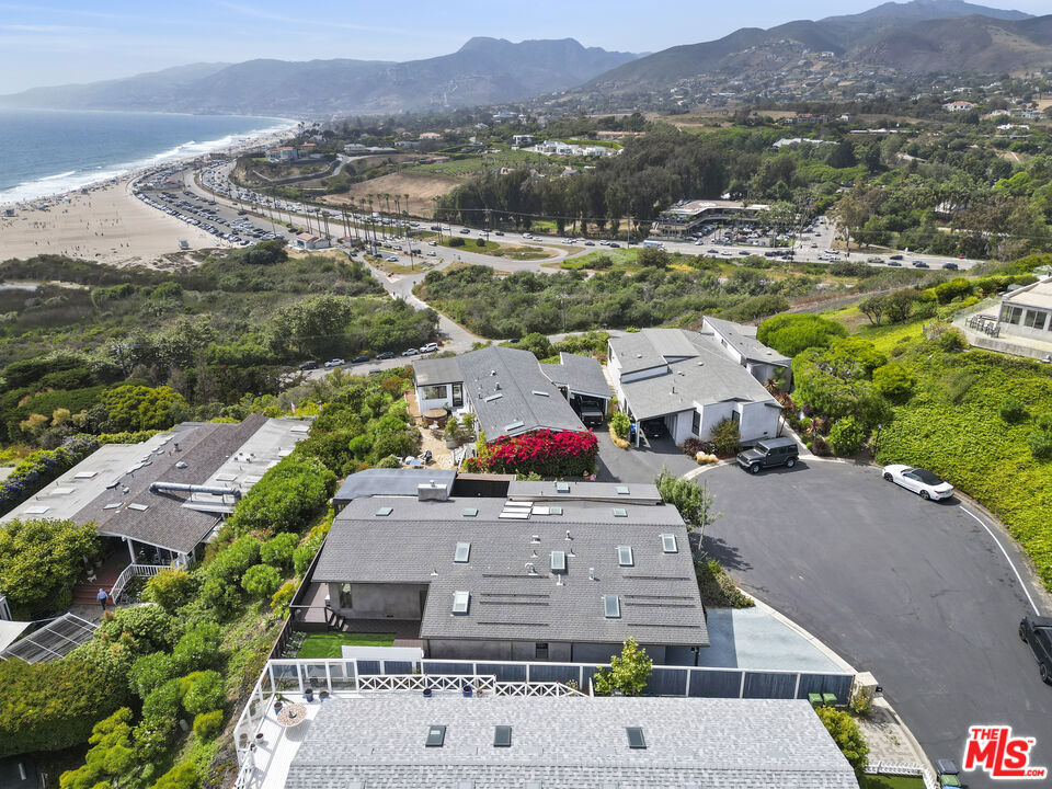 Nestled at the end of a quiet cul-de-sac, on the best street in the famed Point Dume Club, this beautifully appointed home offers sweeping ocean and beach views that will take your breath away. From the moment you enter through the private courtyard, you're welcomed into a bright, open floor plan designed for relaxed seaside living and effortless entertaining. Bathed in natural sunlight, the living spaces flow seamlessly, creating a warm and inviting atmosphere. Large windows capture the stunning views, while the open layout offers flexibility and a sense of spaciousness throughout including a detached studio perfect for use as an at home office, gym or 4th bedroom/guest room. The home features ample storage solutions and generous parking including space for guests making it as practical as it is picturesque. Step outside to enjoy a charming grassy yard, perfect for pets, play, or soaking up the sun in your own serene retreat. Whether you're looking for a peaceful primary residence or the ultimate beachside getaway, this home delivers comfort, style, and a location that's hard to beat. Walk, bike ride or take your golf cart to the beach, market, restaurants...everything you need is close by. Community amenities include 24 hour guard-gated security, clubhouse, pool, spa, sauna, basketball and tennis courts, dog park, playground....