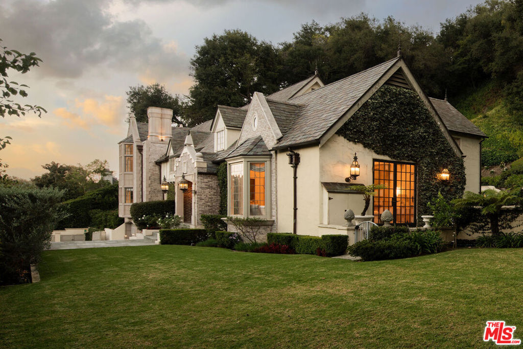 Some homes invite you in. Others take your breath away. 10950 Bellagio Road is the rare estate that delivers both effortlessly. The story begins at the gates, where a sweeping motor court sets the stage for what lies beyond. As you step through the front door, light pours across vaulted ceilings and rustic beams, dancing over a fireplace that anchors the formal living room. Beneath your feet, heated stone floors add a subtle touch of comfort that makes every step feel extraordinary. The kitchen, alive with character, is fitted with a La Cornue range and custom cabinetry. It's not just a place to cook, but to gather around the island for a glass of wine, or in the adjoining dining room where French doors open to your private oasis. Imagine a waterfall cascading 15 feet into a pool below, its sound carrying across every room in the house and terraces designed for long lunches, sunset dinners, or quiet yoga at dawn. Each space whispers relaxation, every corner invites you to linger. Tucked away in its own wing, the primary suite feels like the closing chapter of a perfect day. A marble spa bath, a two-story boutique-style closet, a fireplace to curl up beside, and a private patio overlooking the fairways. All the elements of retreat woven seamlessly together. The home continues with five guest suites, spaces for both celebration and solitude, a custom wine cellar, and even an elevator. And through it all, the sense of place is undeniable: Set within Lower Bel Air, overlooking the 15th fairway of The Bel Air Country Club, this immaculate residence captures the essence of one of the world's most coveted neighborhoods. This isn't just a home reborn, it's a story waiting for its next chapter.