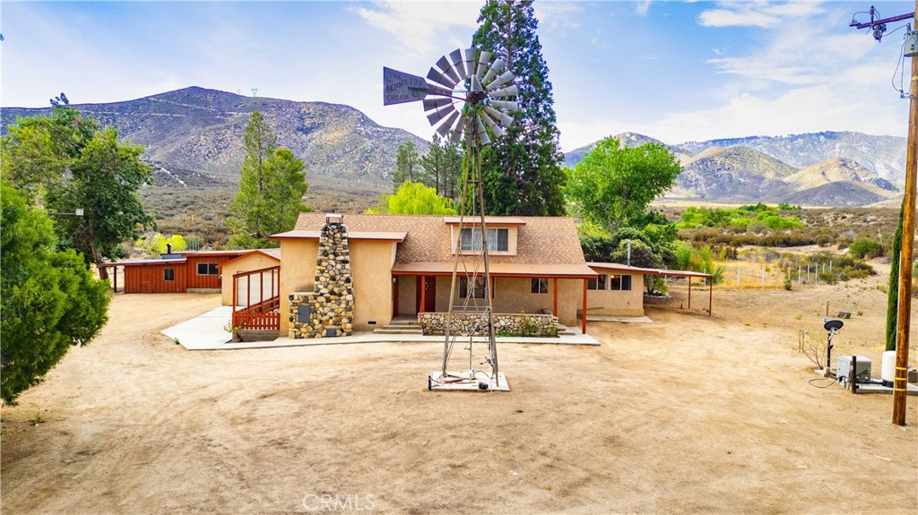 Don't miss out on an opportunity to own this one-of-a-kind property, nestled at the base of Angeles National Forest! Over 8 Acres of prime land, with Gleason Creek running along the western edge, includes deeded water rights, a private well and the infrastructure to begin your own self-sustaining farm. The 3 Bedroom, 2 Bathroom home is spacious, large enough for multigenerational living, with plenty of common areas and storage. The kitchen is the hub of the home, with a butcher block counter and prep sink, a walk-in pantry, and adjacent bonus room with a wood burning stove. Common areas include living, family and dining rooms, plus an office with its own bathroom, large enough to convert back to a bedroom. The west wing of the house is private, with its own entrance, adjoining laundry room and Primary Bedroom and Bathroom. Upstairs is a bunk-style room, complete with built-in storage and large enough for multiple beds. The yard has a large workshop; aviary; barn for farm animals; fruit trees, hog runs, chicken coup, vegetable planters; a pond and cemented stream with seasonal access. A whole house generator and full RV hookups is a welcomed convenience. Just 45 miles to Los Angeles on the outskirts of Acton, the property is close to shopping, restaurants, schools and is commuter friendly. Come savor the views, tranquility and privacy that this home delivers.