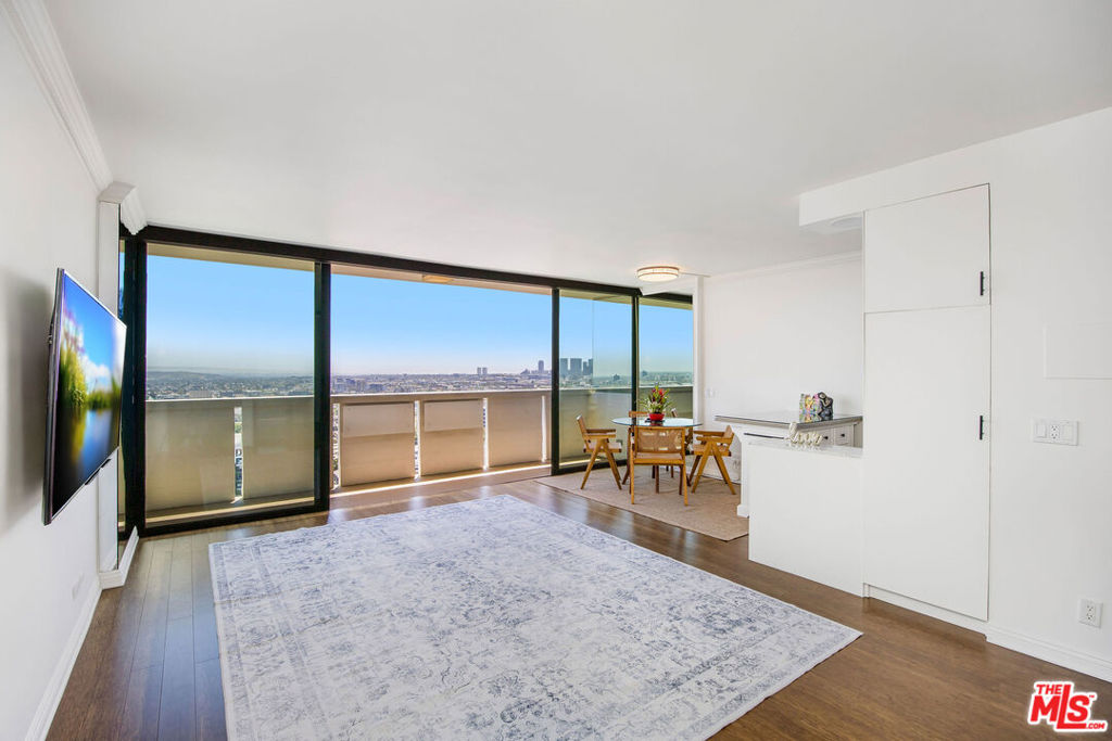 Set high above the iconic Sunset Strip, this elegantly appointed upper-floor residence at Shoreham Towers offers sweeping, unobstructed views that span from Century City to Downtown Los Angeles and even to the Pacific Ocean on clear days! The panorama of glittering city lights is nothing short of spectacular. This contemporary one bedroom, one-bathroom featuring a spacious open-concept layout designed for effortless living. Floor-to-ceiling windows fill the interior with natural light and frame the dramatic skyline, while the expansive private terrace extends the living space outdoors. The sleek, modern kitchen is both stylish and ideal for those with an active lifestyle. Throughout the home, rich hardwood floors and thoughtfully curated designer details create an atmosphere of elegance and warmth. The primary suite serves as a tranquil retreat, outfitted with double-paned sliding doors and blackout shades for optimal privacy and comfort. Bedroom area fits queen size bed. A fully customized walk-in closet and a spa-inspired bathroom with elevated finishes complete this sophisticated sanctuary. Located in one of Los Angeles' most prestigious full-service buildings, Shoreham Towers offers residents an effortless luxury lifestyle with 24-hour concierge, attentive doorman service, valet parking, a resort-style pool, and a state-of-the-art fitness center. Just moments from Sunset Strip and West Hollywood's premier dining, shopping, and entertainment, this residence embodies the best of elevated city living.