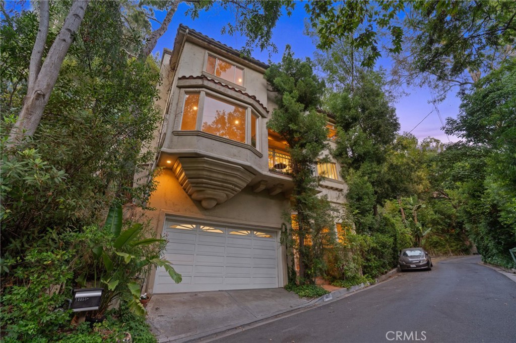 Are you seeking a blend of vibrant city life and restorative canyon living? Then come discover the Canyon Chateau at 10055 Reevesbury Drive, the quintessential Beverly Hills sanctuary where creative inspiration thrives.
From the street, the home’s imposing façade exudes timeless European charm; its three levels, partially concealed by mature leafy trees. Inside, the journey begins in a marble-floored entry, leading to a versatile guest room/home office, bathed in natural light, full bath and convenient access to a spacious two-car garage.
The main level invites grand scale living. A great room with expansive west-facing windows framing lush hillside views, a working wood-burning fireplace and an open chef’s kitchen, ideal for entertaining while prepping meals. On this floor, a generous second bedroom with full bath and private courtyard offers a peaceful nook for reflection.
Ascend to the top level, where the heart of this creative retreat unfolds in a primary suite with soaring ceilings, gas burning fireplace, separate sitting room, and over 1,000/sf of luxurious comfort. Imagine stepping onto a private terra cotta terrace, surrounded by shade trees and vibrant landscaping. And revel in the spa-inspired marble bathroom with jetted tub, glass-enclosed shower, and two walk in closets.
Located on a tranquil, dead-end street, nature enthusiasts will delight in year-round greenery and lively birdsong that enchants during morning and evening strolls. For families with children, the home enrolls to Warner Elementary, or you can tap into the Beverly Hills School system. And being just 3 miles north of Sunset, you are moments from world-class dining, shopping and nightlife options.
The next owner will want it all, canyon stillness and city energy, luxury and laidback. Discover all that and more at the Canyon Chateau where every detail is designed to inspire your daily life