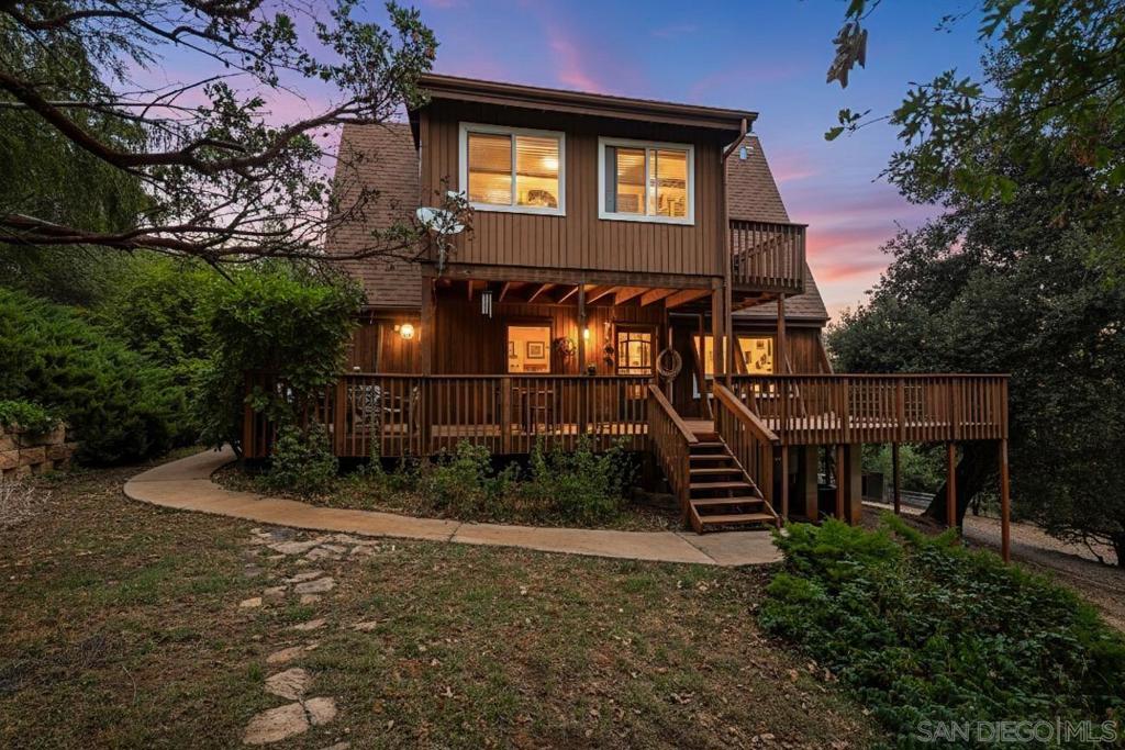 Enjoy this mountain Cabin, within short walking distance to the multi-use hiking, biking, and equestrian trails at William Heise County Park. The property is .79 acres, fully fenced, and the cabin features two comfortable decks: a private deck off the upstairs bedroom and a large, family-sized deck with plenty of room for entertaining, conveniently located off the kitchen. From here, you will enjoy peaceful mountain views and ample space for your pet to run. Inside, you will find a cozy living area featuring a large fireplace, cedar siding, vaulted ceilings, and tall windows that provide ample natural light. The home features two official bedrooms and two optional bedrooms, as well as a detached two-car garage that includes a weight room. Stay comfortable with forced central heating and air conditioning, plus a Generac generator for reliable power back-up when needed. The current owners have cherished this property and raised their young, happy children here from elementary school through to adulthood, forming many precious memories. Outdoor features include mature apple, cherry, and apricot trees, as well as grapevine, strawberry plants, and mint. You'll find horse shelters, an area for a small flat riding arena, a tack room, a chicken coop, and a goat shelter as well. The property also backs up to Heise Park, offering great riding trails. Zoned for agriculture, this property allows for a variety of home farming activities. It's ideal for those seeking to cultivate their own food and raise animals. Schedule a showing today!