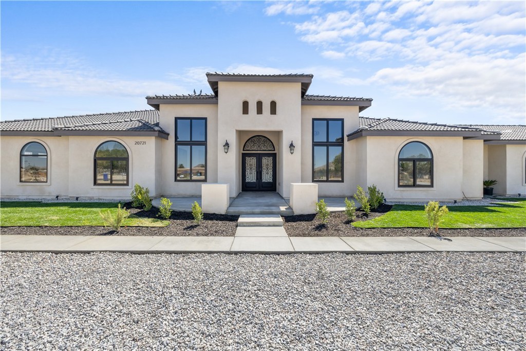 Welcome to 20721 Standing Rock Avenue. This BRAND NEW custom-built residence offers an impressive 3,404 square feet of sophisticated and comfortable living space, showcasing 5 spacious bedrooms, two of them being full bedroom suites, and 4 generously sized full bathrooms. A grand entry with double wrought-iron doors welcomes you to a flawless open floor plan with soaring 13ft and 11ft ceilings throughout the home allowing abundance of natural light. The modern kitchen is truly a chef's delight with two oversized islands with marble countertops ideal for meal preparation or family gatherings. Custom full cherry wood frame fitting cabinets with soft closing glassed faced doors and dovetail drawers are a hallmark of luxury craftsmanship in this home. Fully equipped with stainless steel high-end Thor appliances featuring a 48 inch six-burner range and matching hood, this chef-inspired kitchen is both stylish and functional. A spacious walk-in pantry offers generous storage. Elegant custom chandeliers as well as recessed lighting illuminate the arched hallways that lead to the bedrooms. As you enter the double doors to the primary suite you’ll find a peaceful retreat with its very own private patio, a spa-inspired bath including an impressive shower, freestanding jet tub, dual vanities and his and her walk-in closets. The interior of this home showcases many upgraded details such as the 8ft solid wood doors throughout and the smoked glass sliding closet doors in the bedrooms. A stand out feature in this home are the large black aluminum, double pane, argon filled insulated, 5 inch framed windows that open and lock automatically from either side with sliding heavy-duty screen. With an oversized, fully fenced back yard you get RV access and endless possibilities to fit your needs. Two immense full concrete driveways lead to a two car garage on both ends of the house, giving you a total of 4 car garage spaces. Both garages are fully finished and feature recessed lighting. This home is equipped with two full AC units and paid off solar! Situated in a prime estate location with paved roads this residence is centrally located within walking distance to shopping, restaurants, community park swimming pool, police and fire station. Nearby shops include Target, Walmart, Albertsons, Ross, amongst many familiar restaurants and the public Apple Valley Golf Course. Great neighborhood and neighbors. Don't miss the opportunity to make this exquisite property your own!